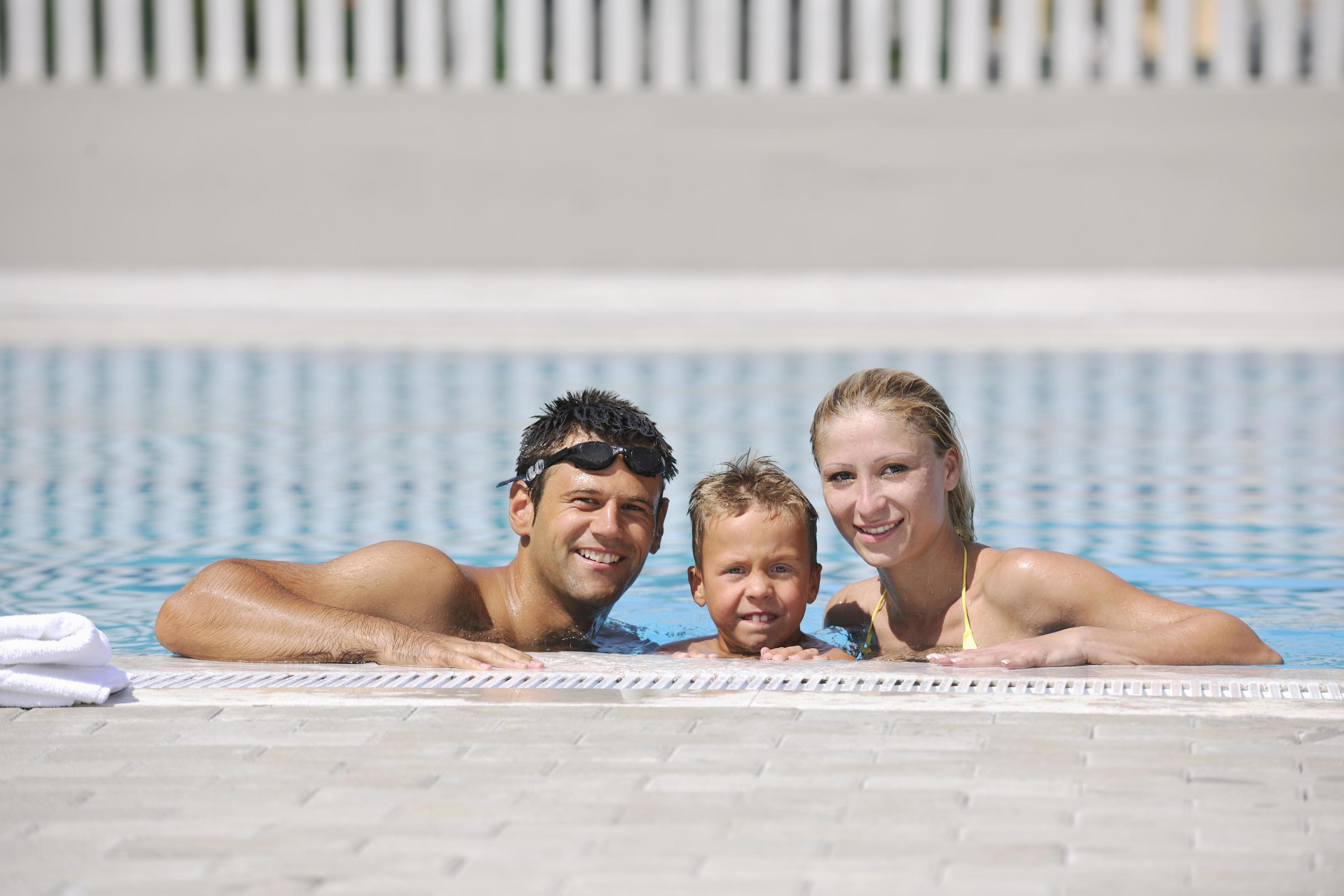 happy young family have fun on swimming pool Stock Free