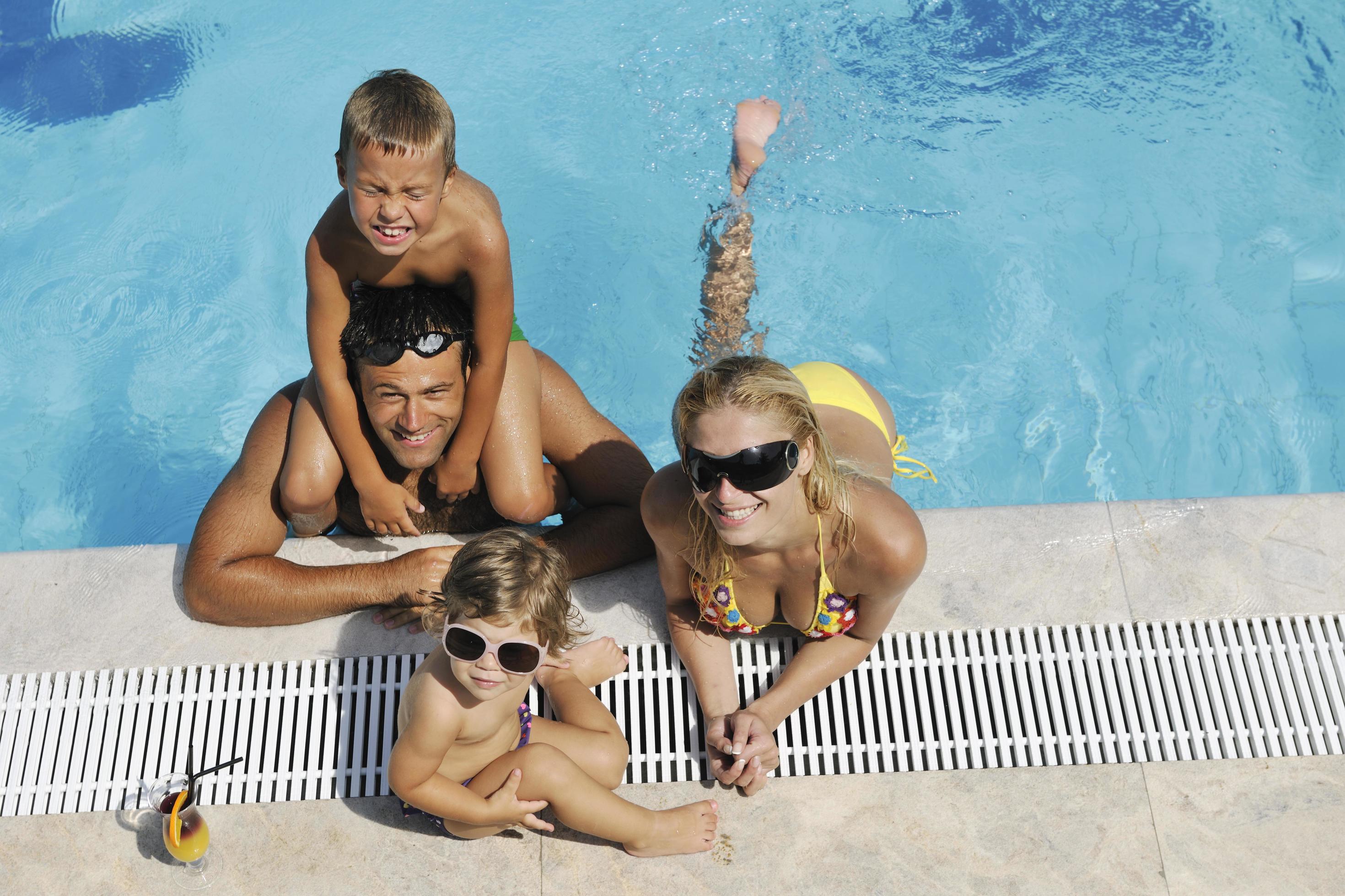 happy young family have fun on swimming pool Stock Free