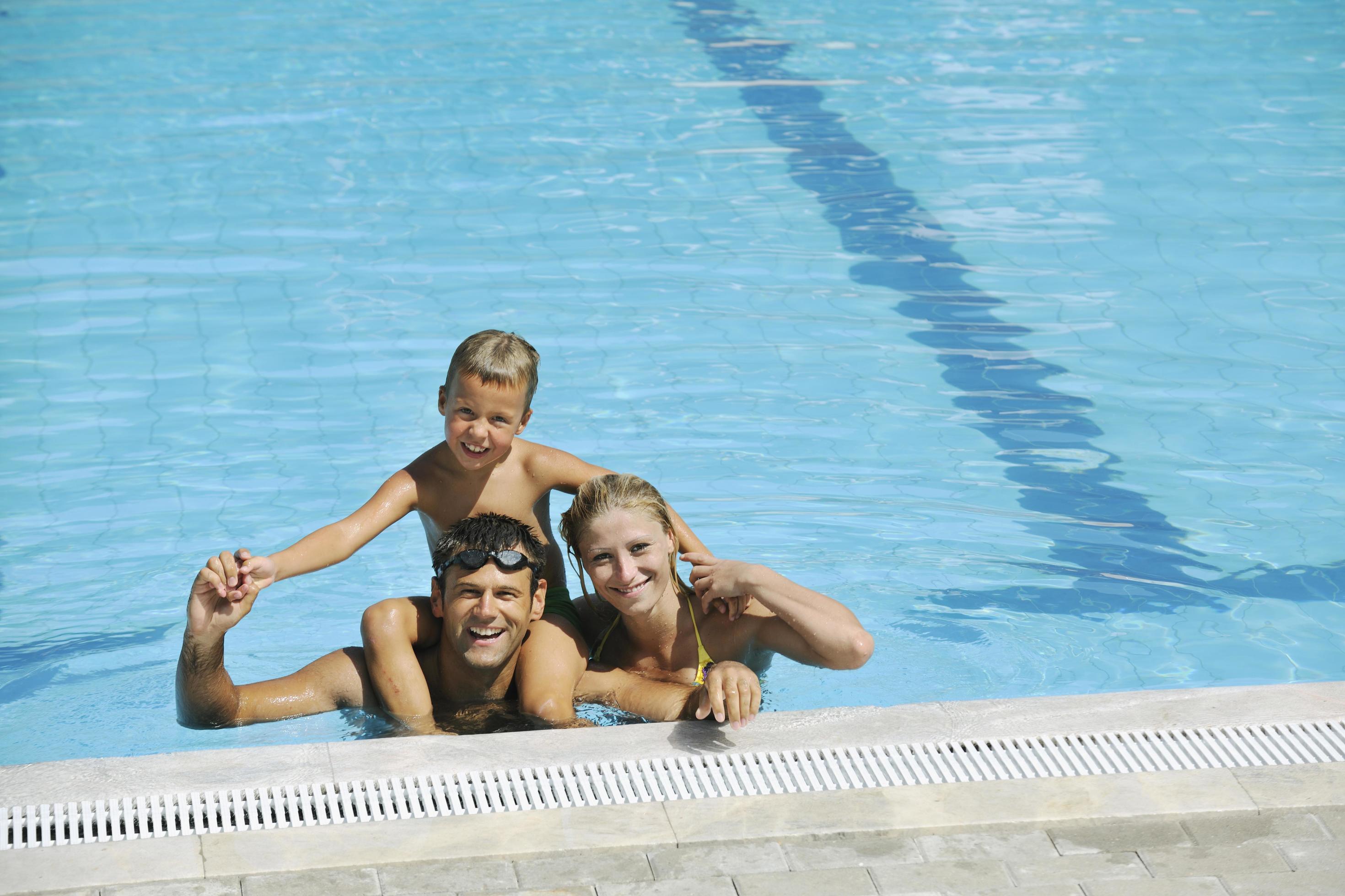 happy young family have fun on swimming pool Stock Free