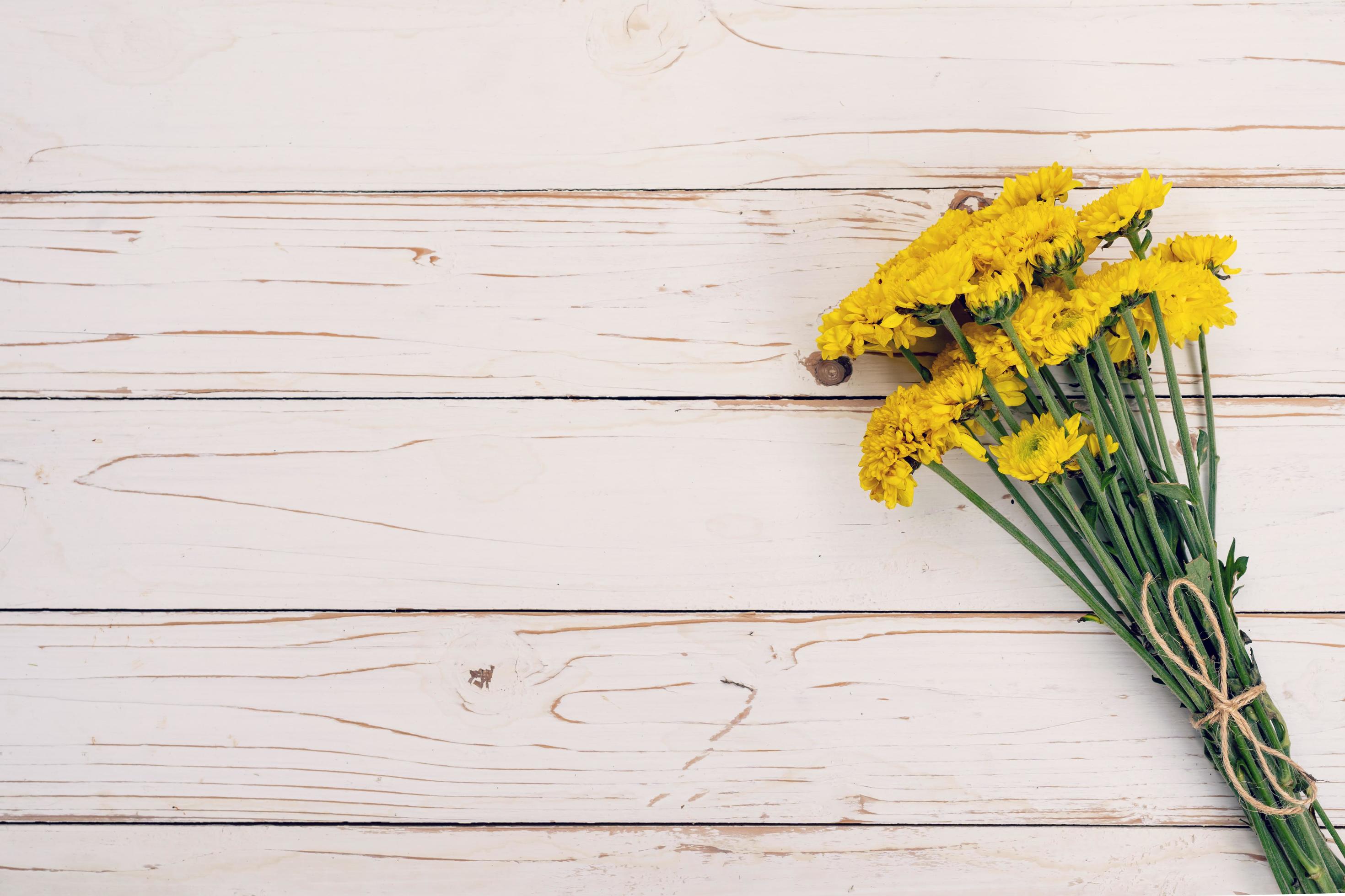 Yellow flowers of bouquet, top view on white wooden background texture with copy space Stock Free