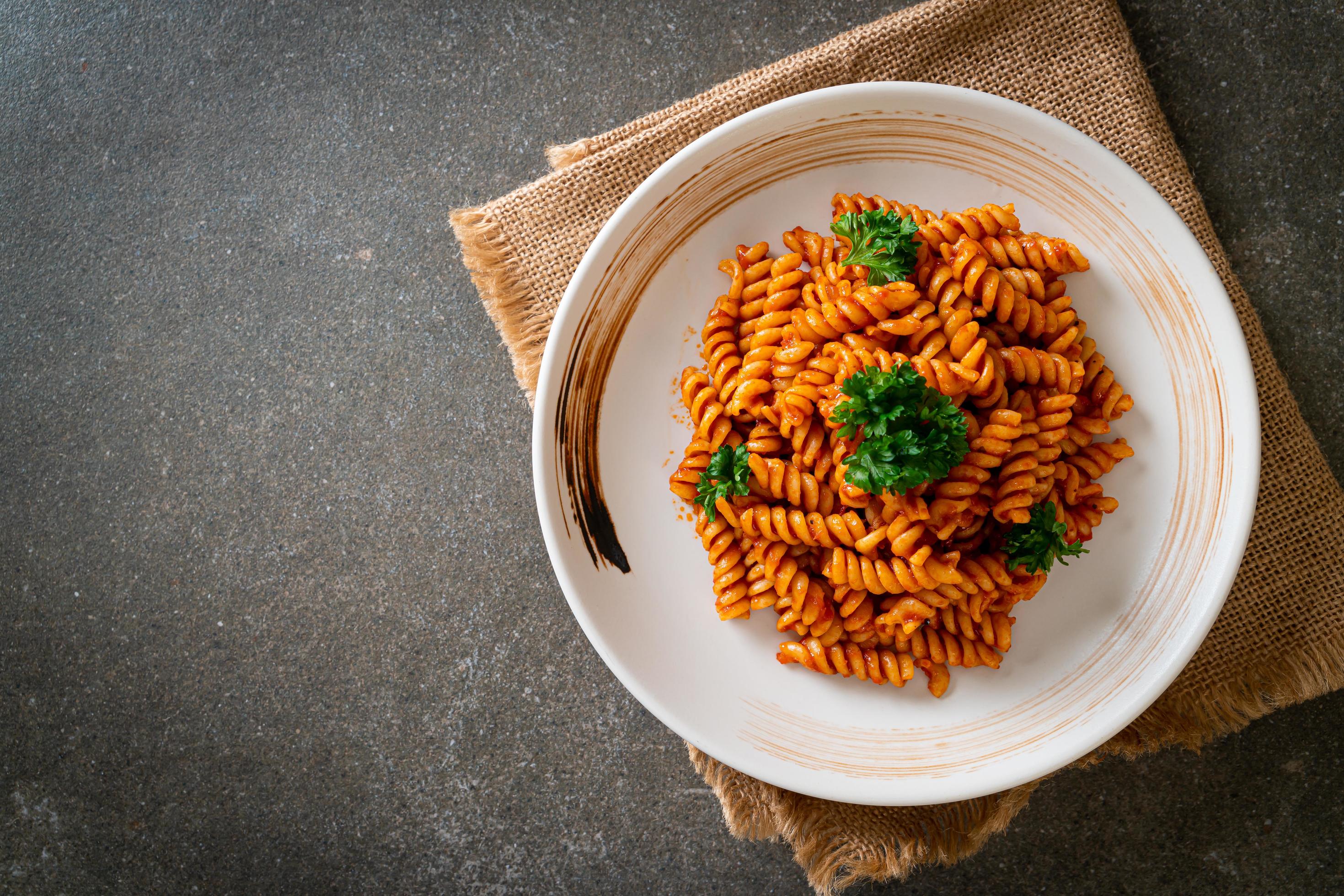 Spiral or spirali pasta with tomato sauce and sausage – Italian food style Stock Free