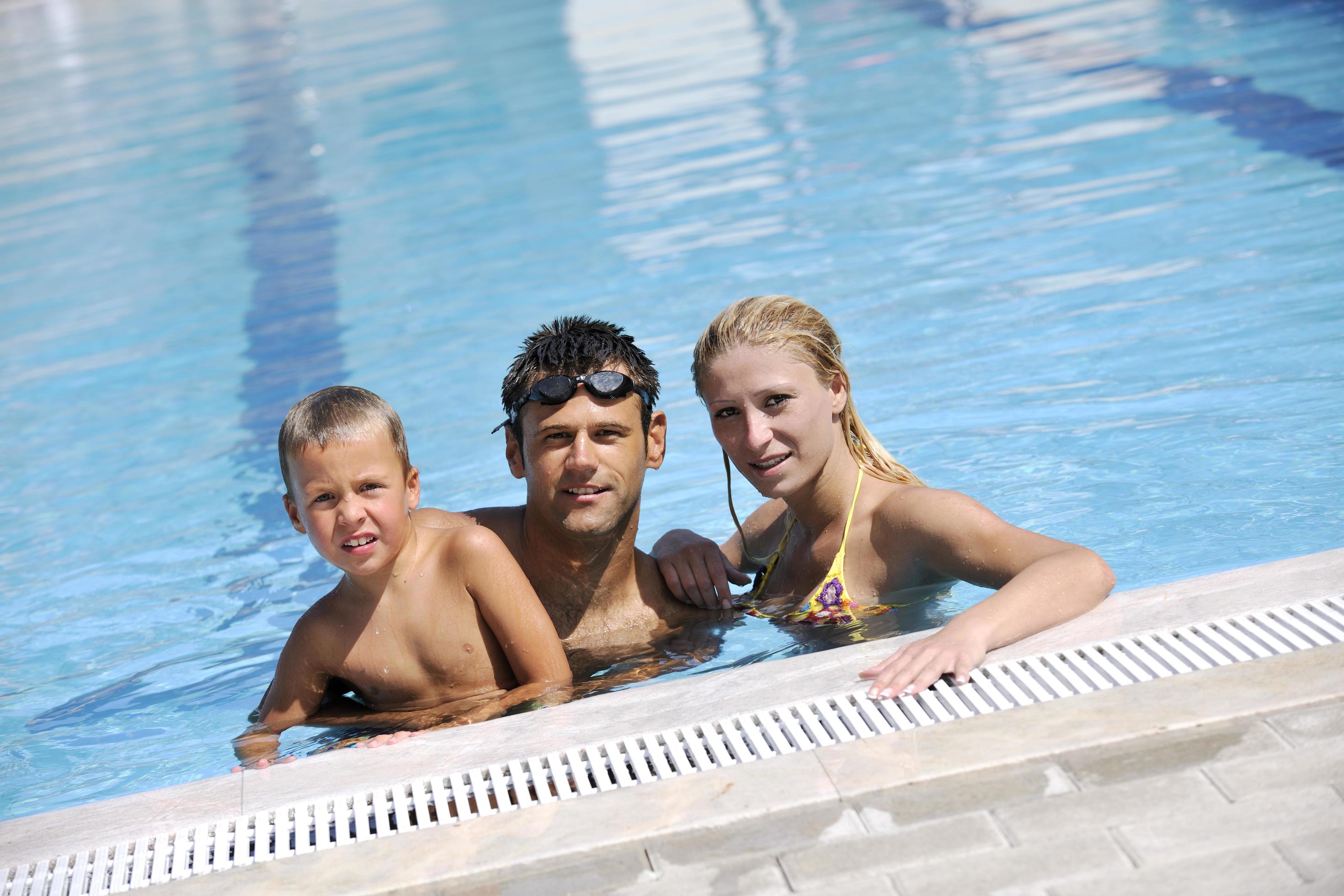 happy young family have fun on swimming pool Stock Free