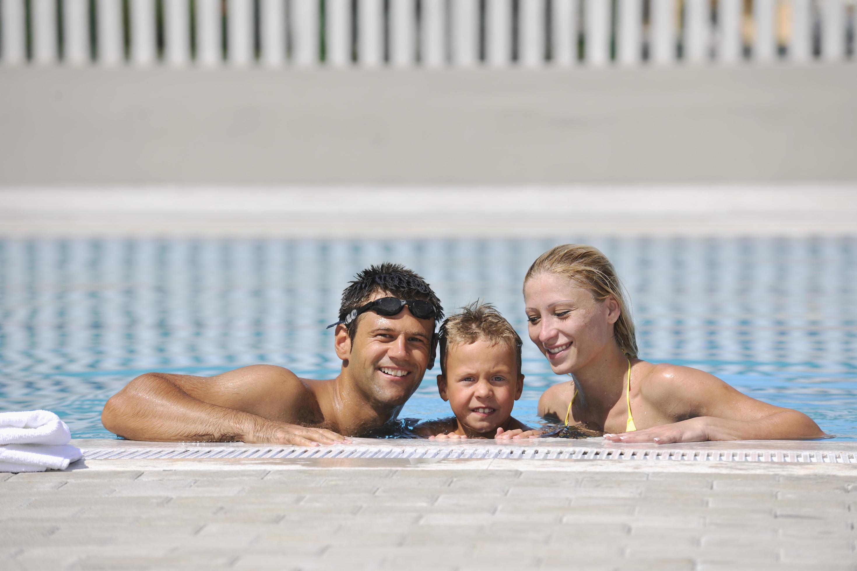 happy young family have fun on swimming pool Stock Free