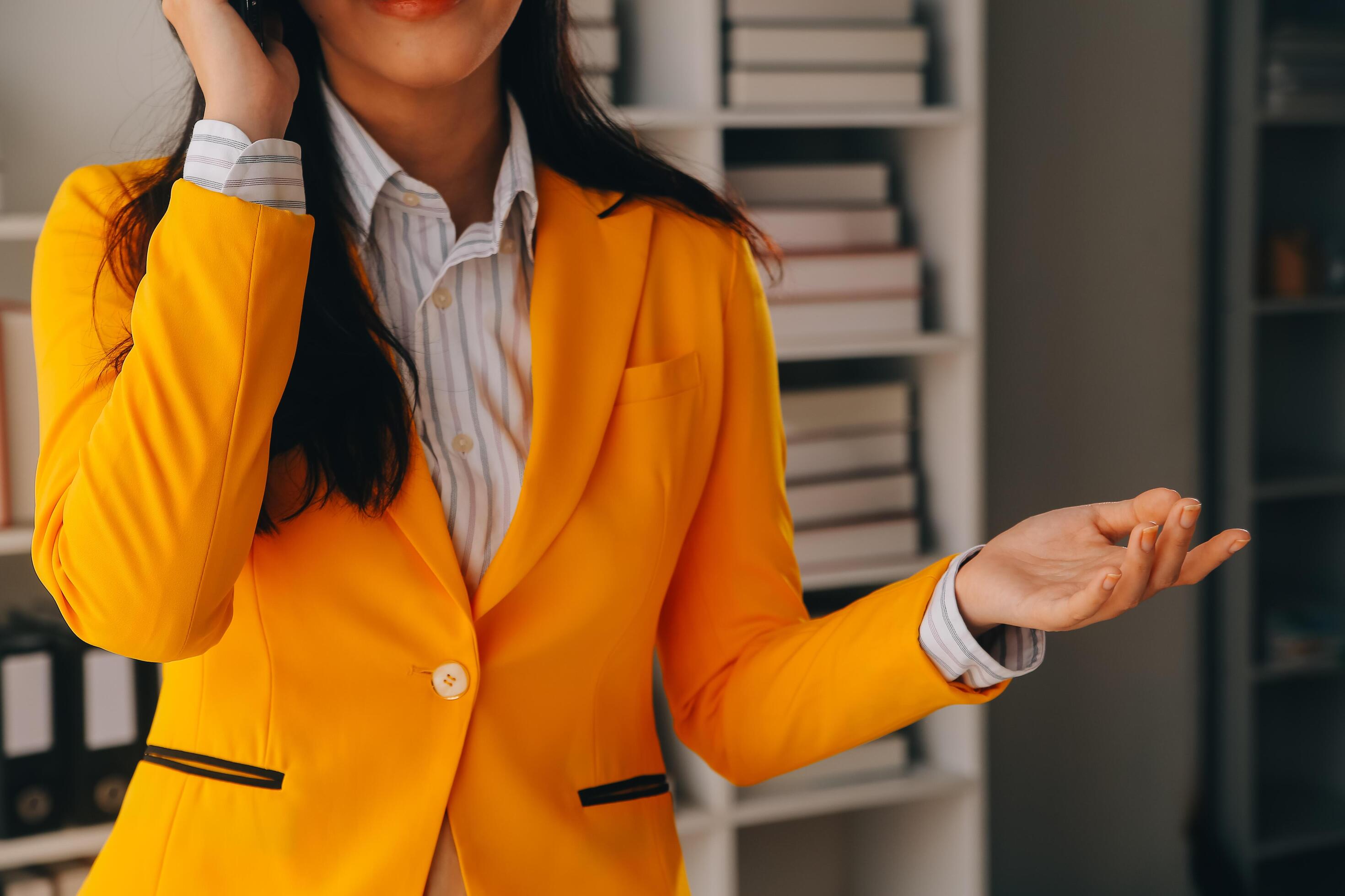 Young smiling business woman using smartphone near computer in office, copy space Stock Free