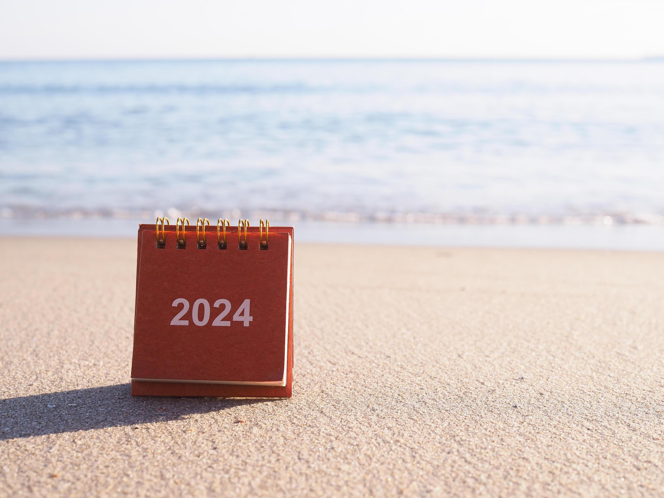 Close up 2024 desk calendar on the beach in the sunset time. Resolution, Goal, Action, Planning, and manage to success business. Stock Free