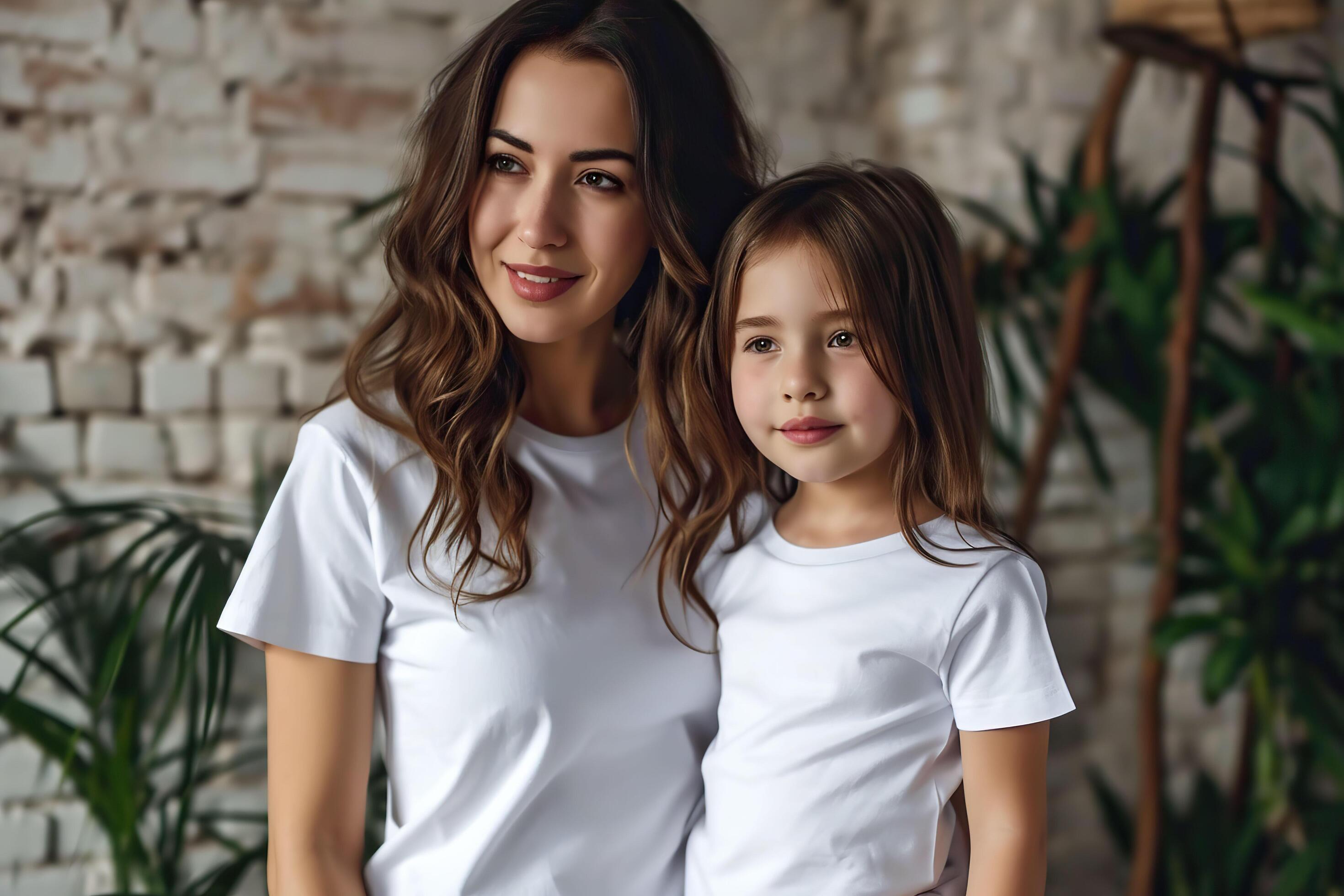 Portrait of a beautiful young mother and her little daughter in white t-shirts. Stock Free