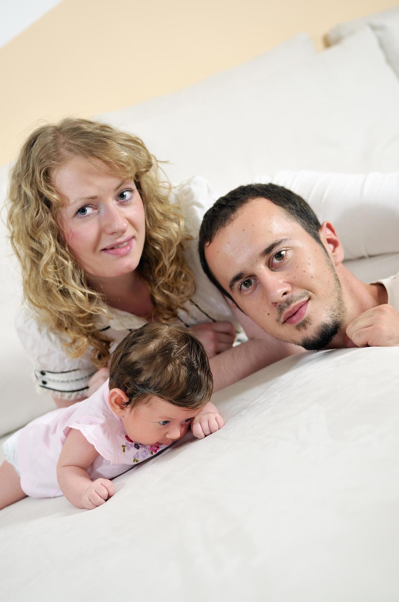 indoor portrait with happy young family and cute little babby Stock Free