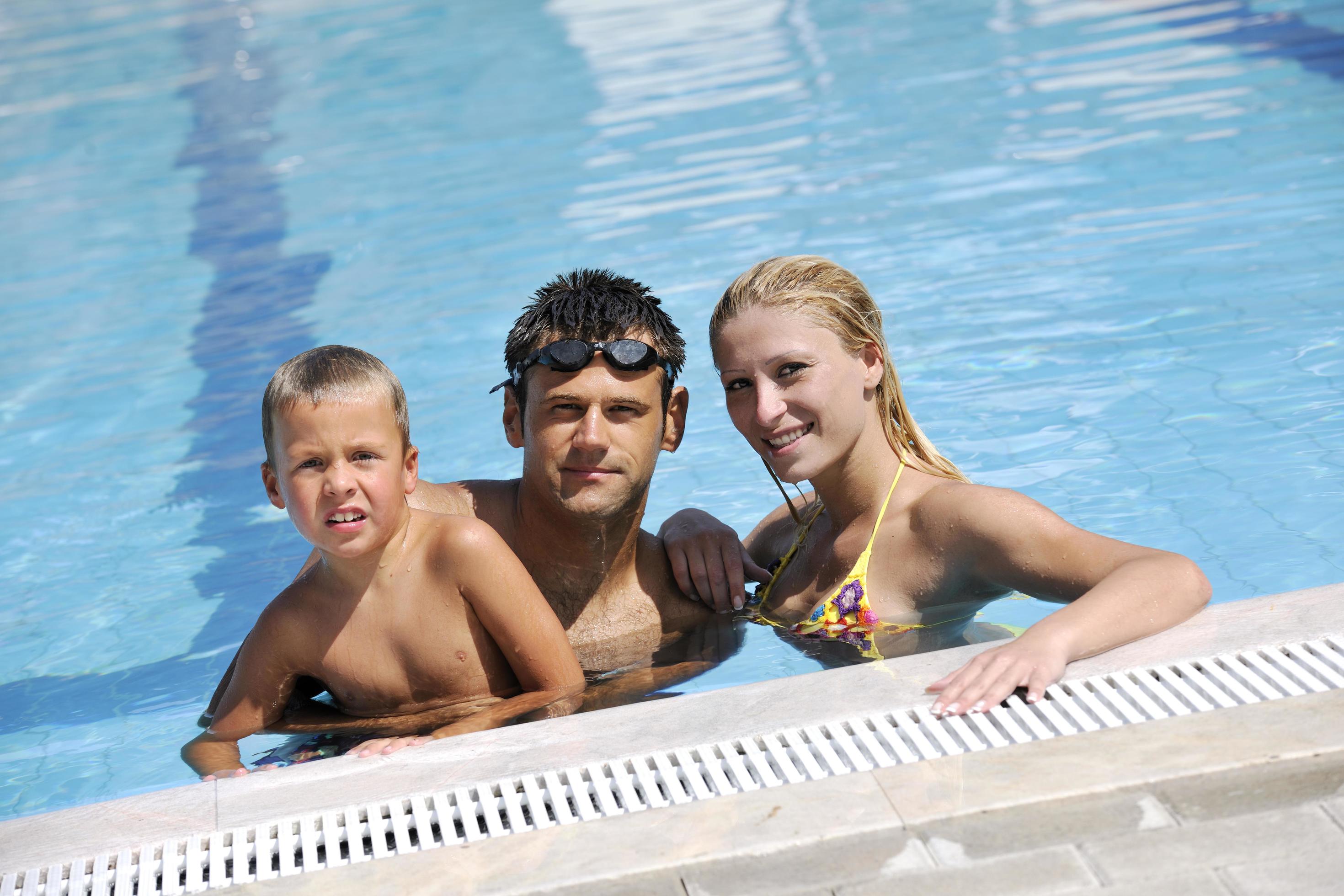 happy young family have fun on swimming pool Stock Free