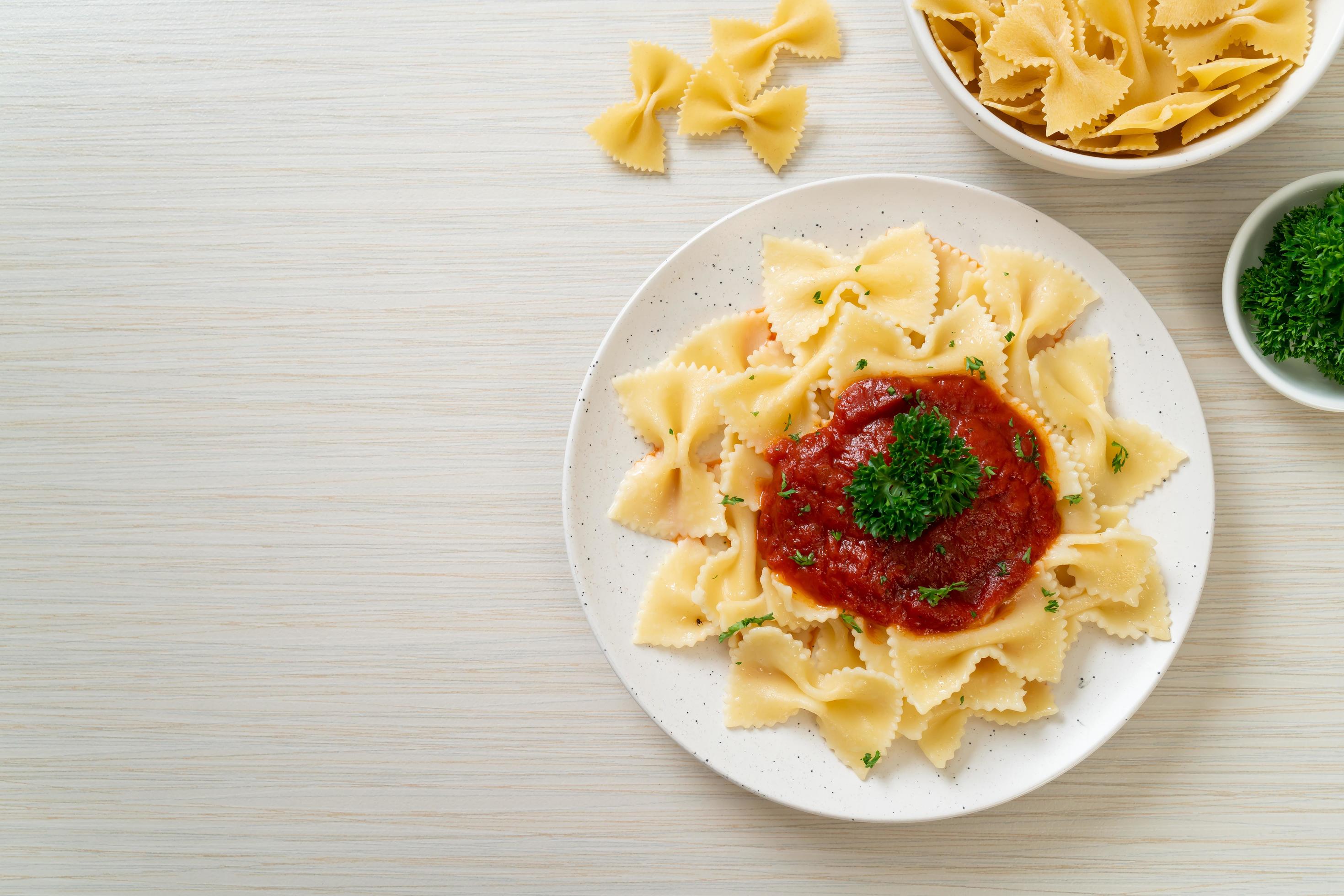 Farfalle pasta in tomato sauce with parsley – Italian food style Stock Free