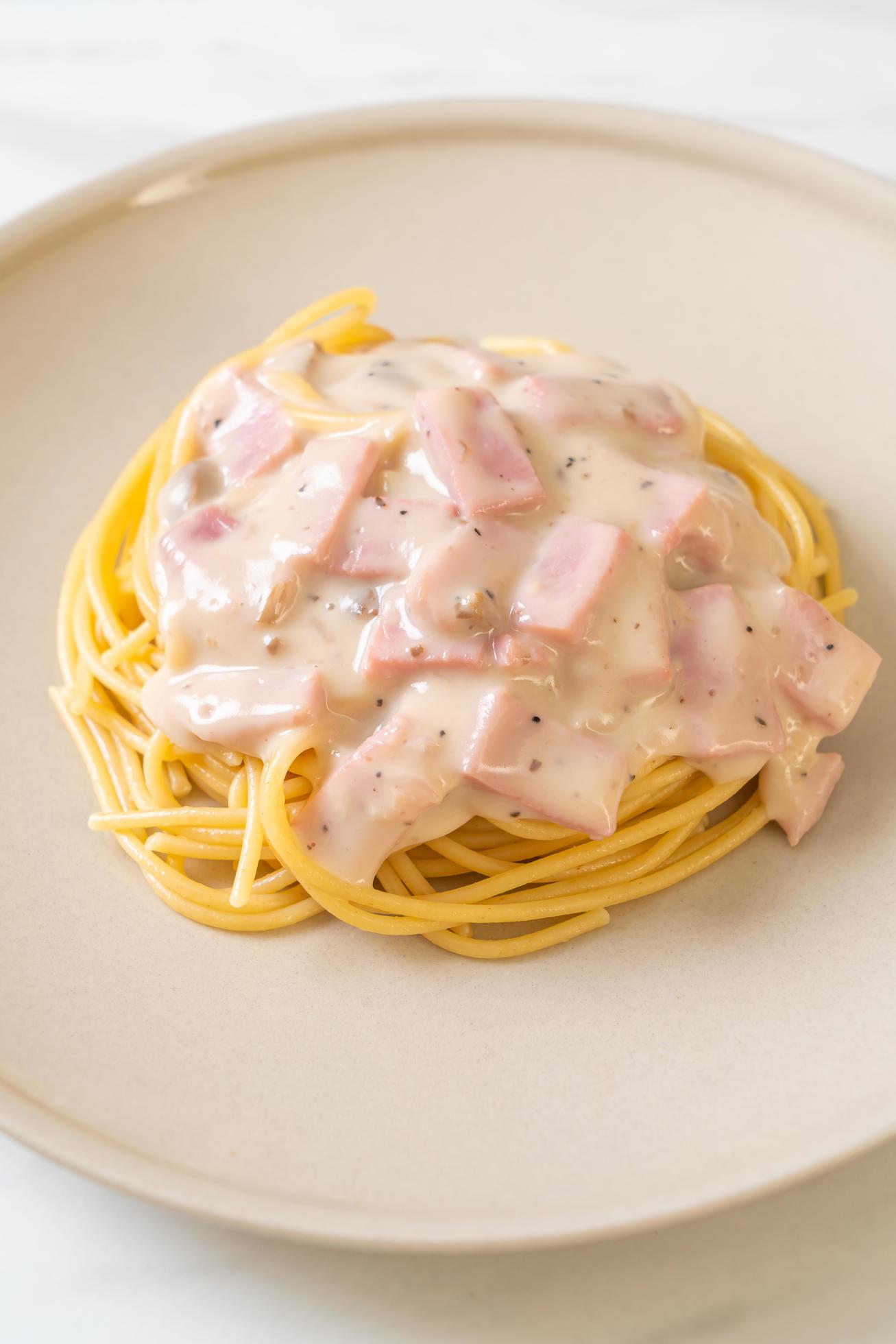 Homemade spaghetti white cream sauce with ham – Italian food style Stock Free