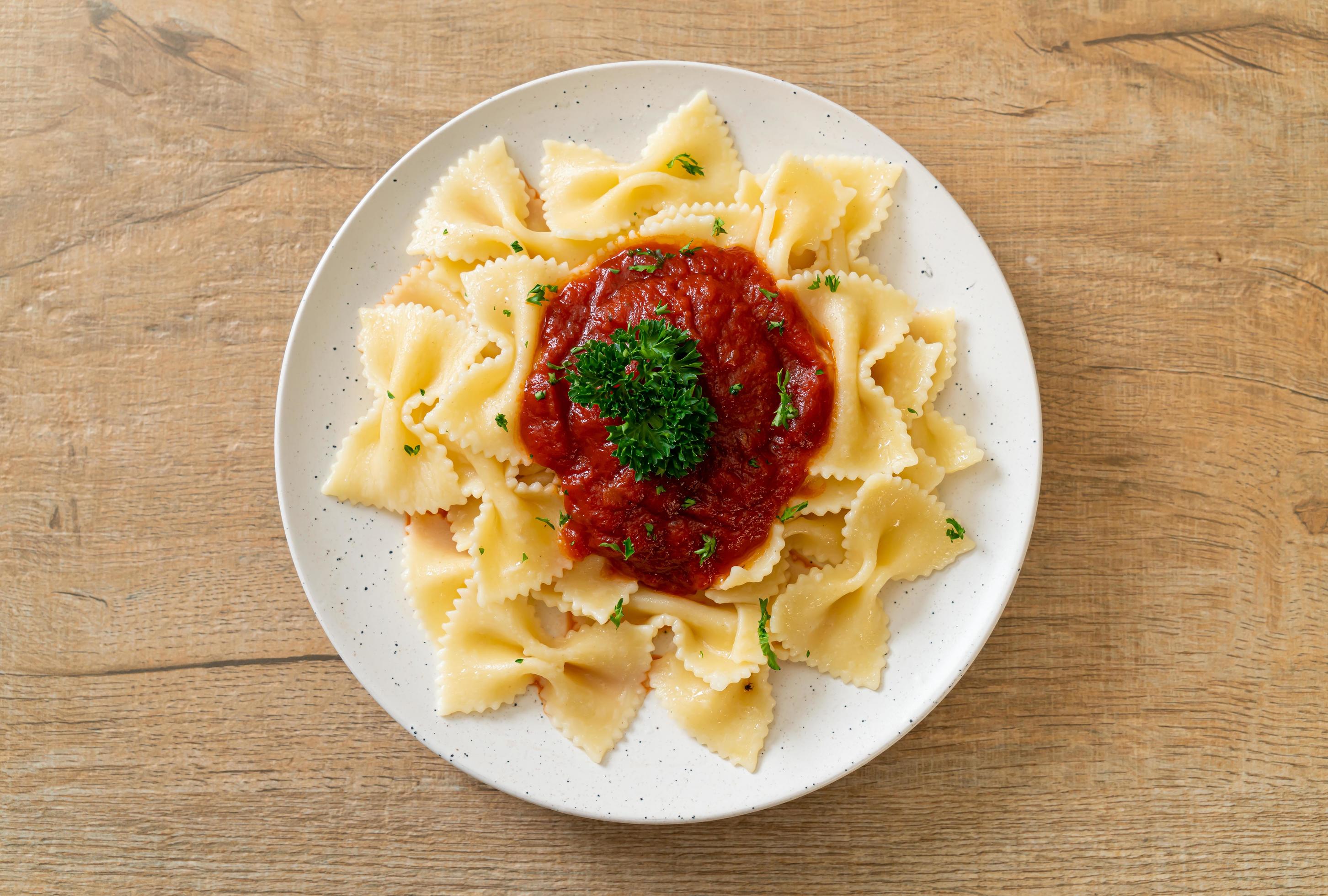 Farfalle pasta in tomato sauce with parsley – Italian food style Stock Free