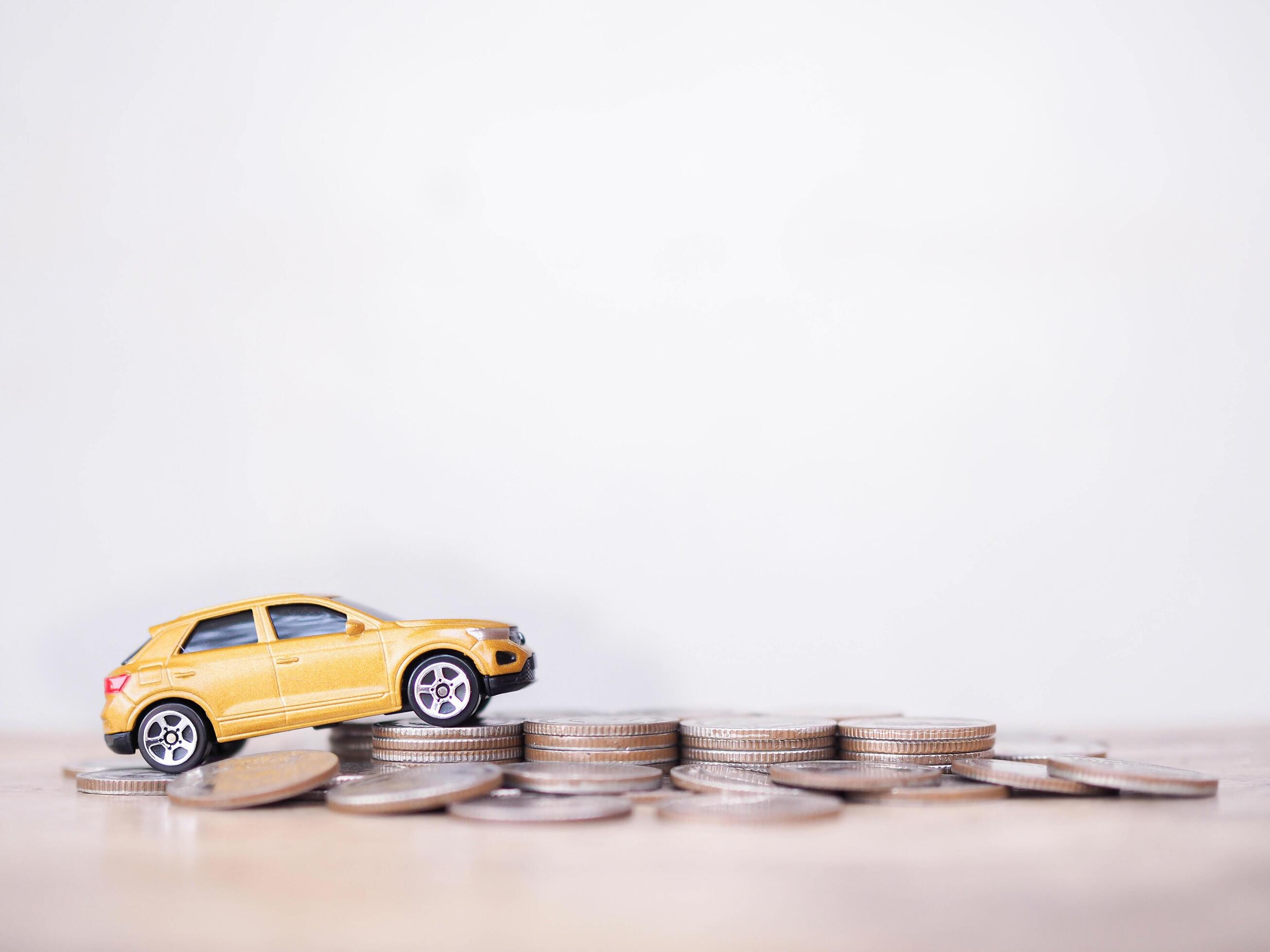 Toy cars on stack of coins. The concept of saving money and manage to success transport business Stock Free