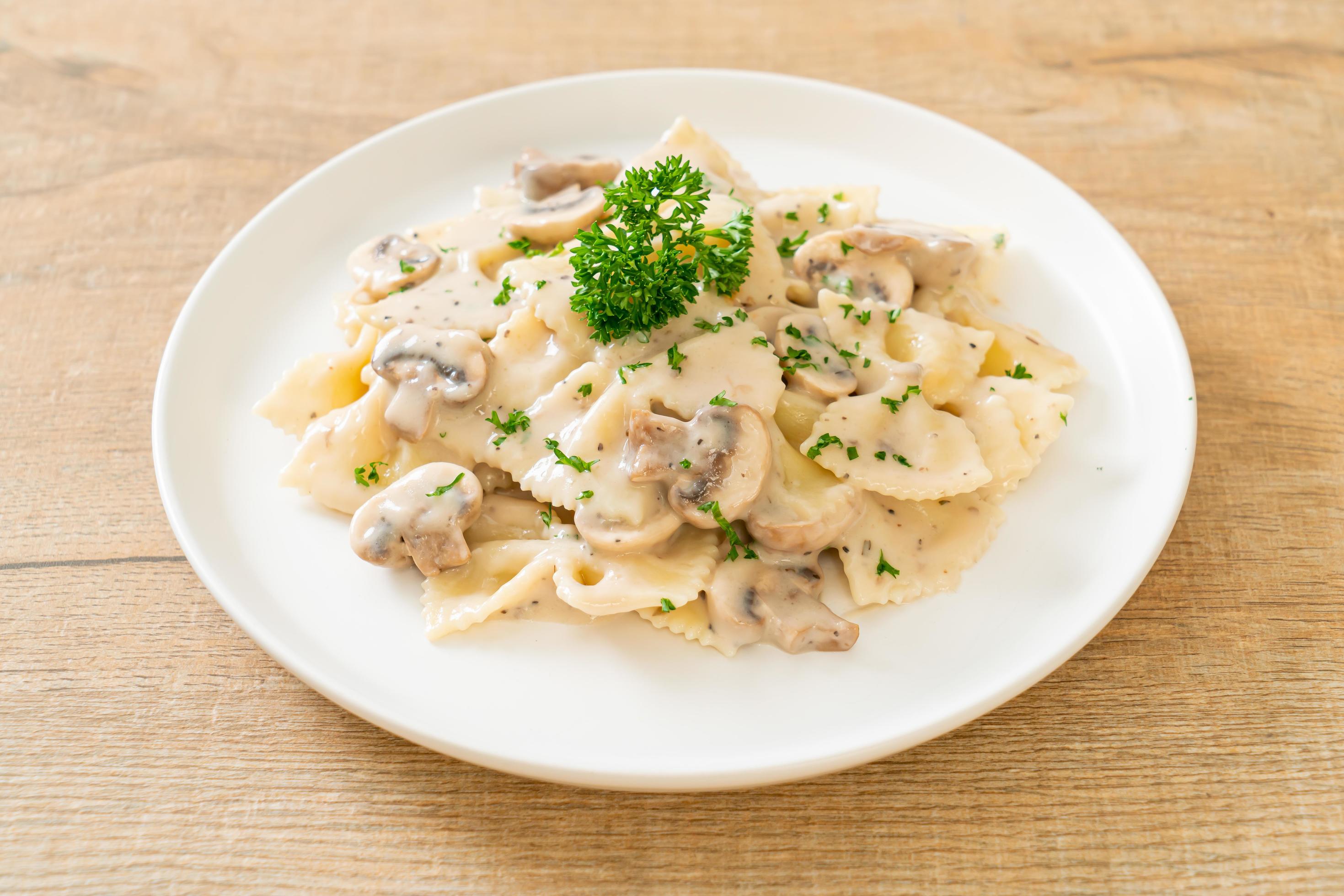 Farfalle pasta with mushroom white cream sauce – Italian food style Stock Free