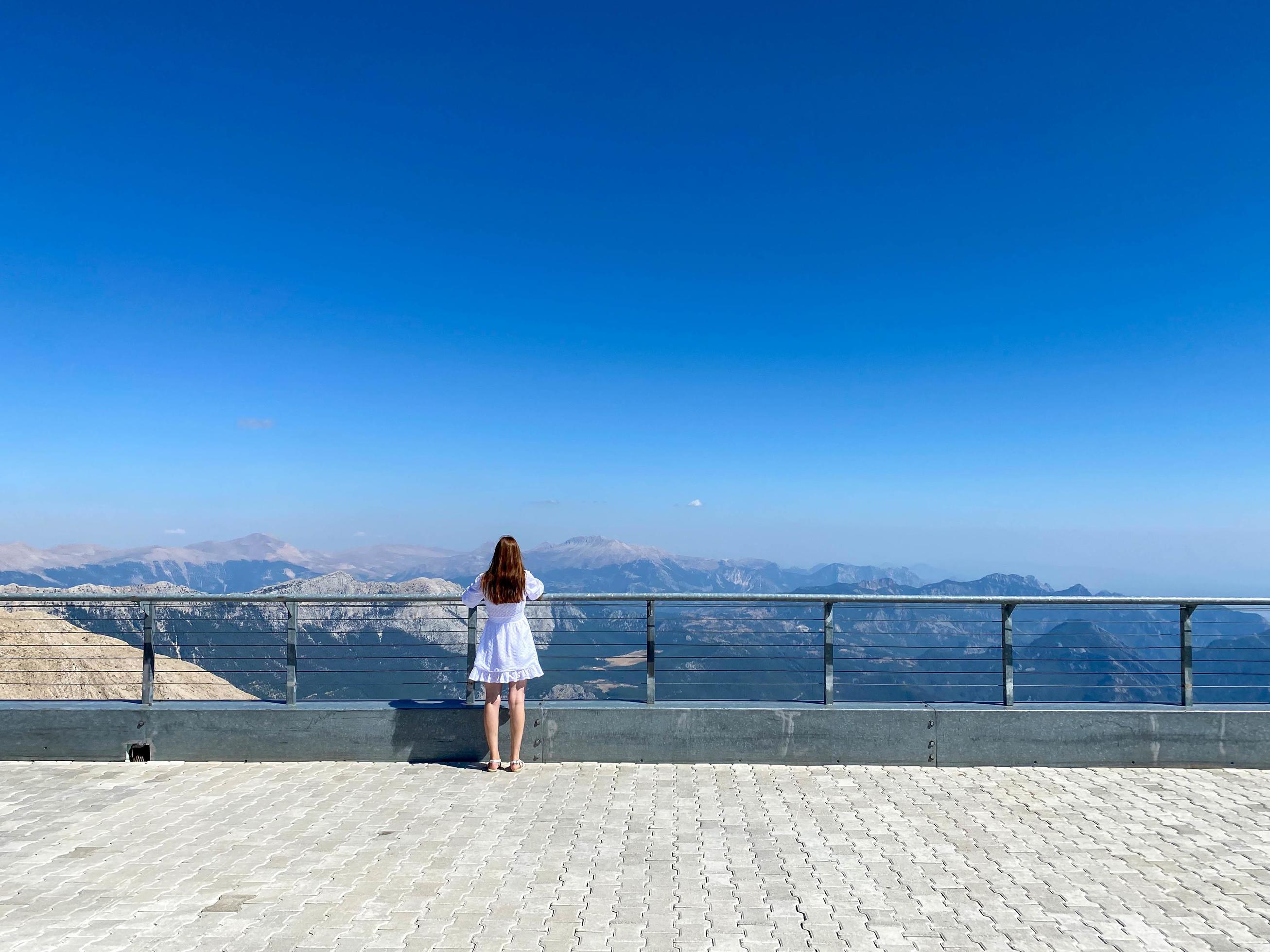 Woman at the observation deck in a deep canyon – breathtaking views of nature in the mountains Stock Free