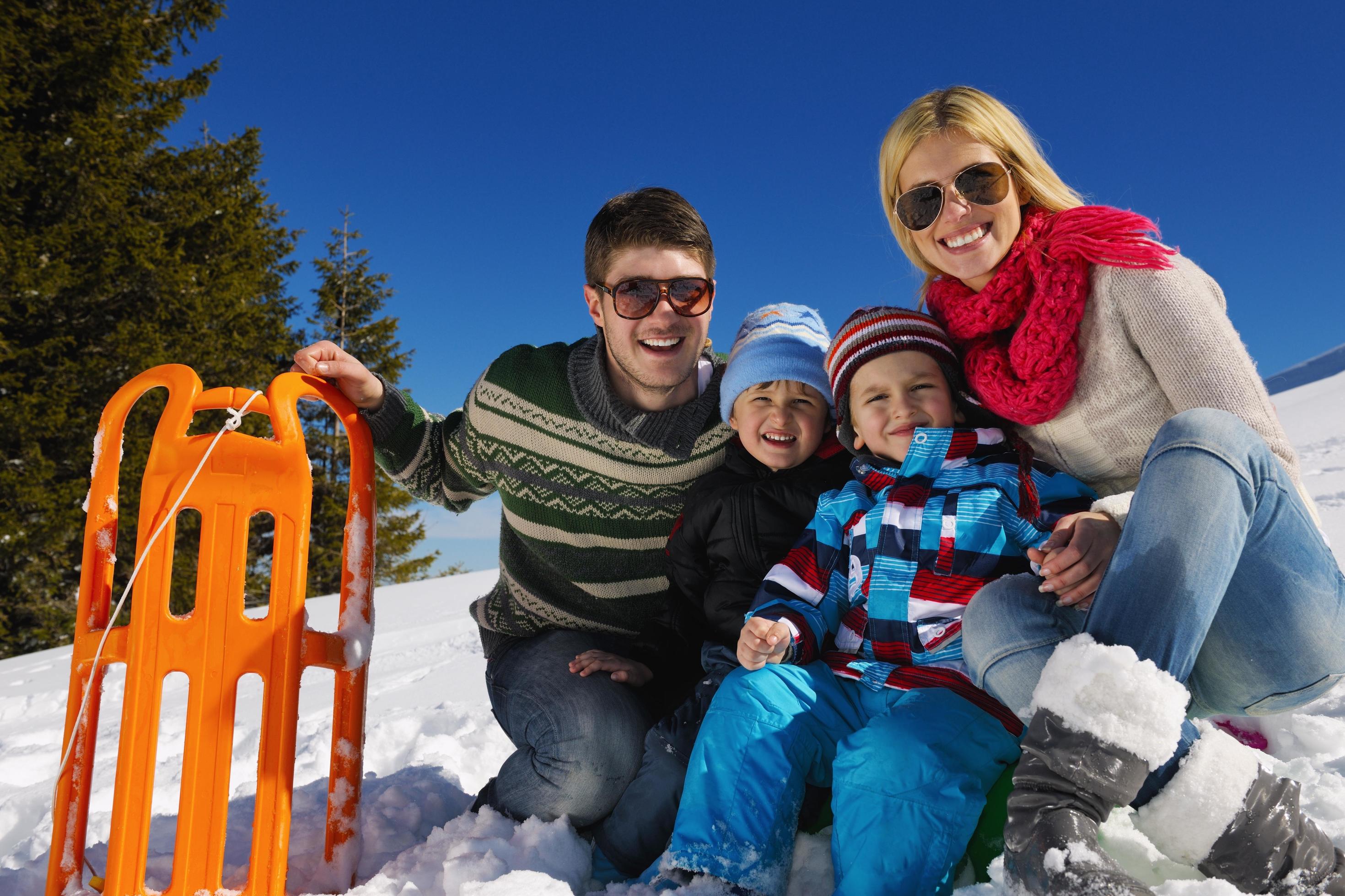 family having fun on fresh snow at winter vacation Stock Free