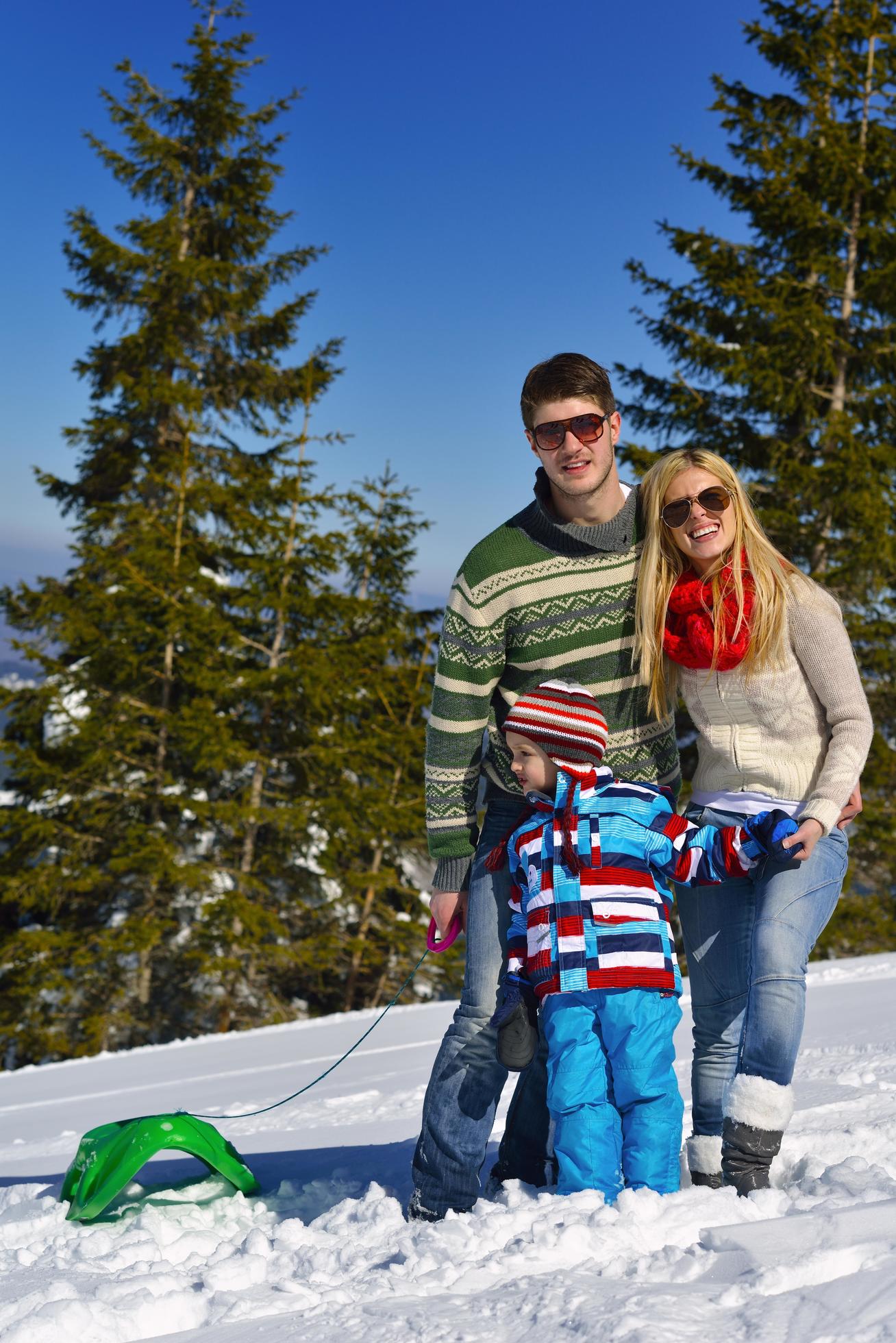 family having fun on fresh snow at winter vacation Stock Free