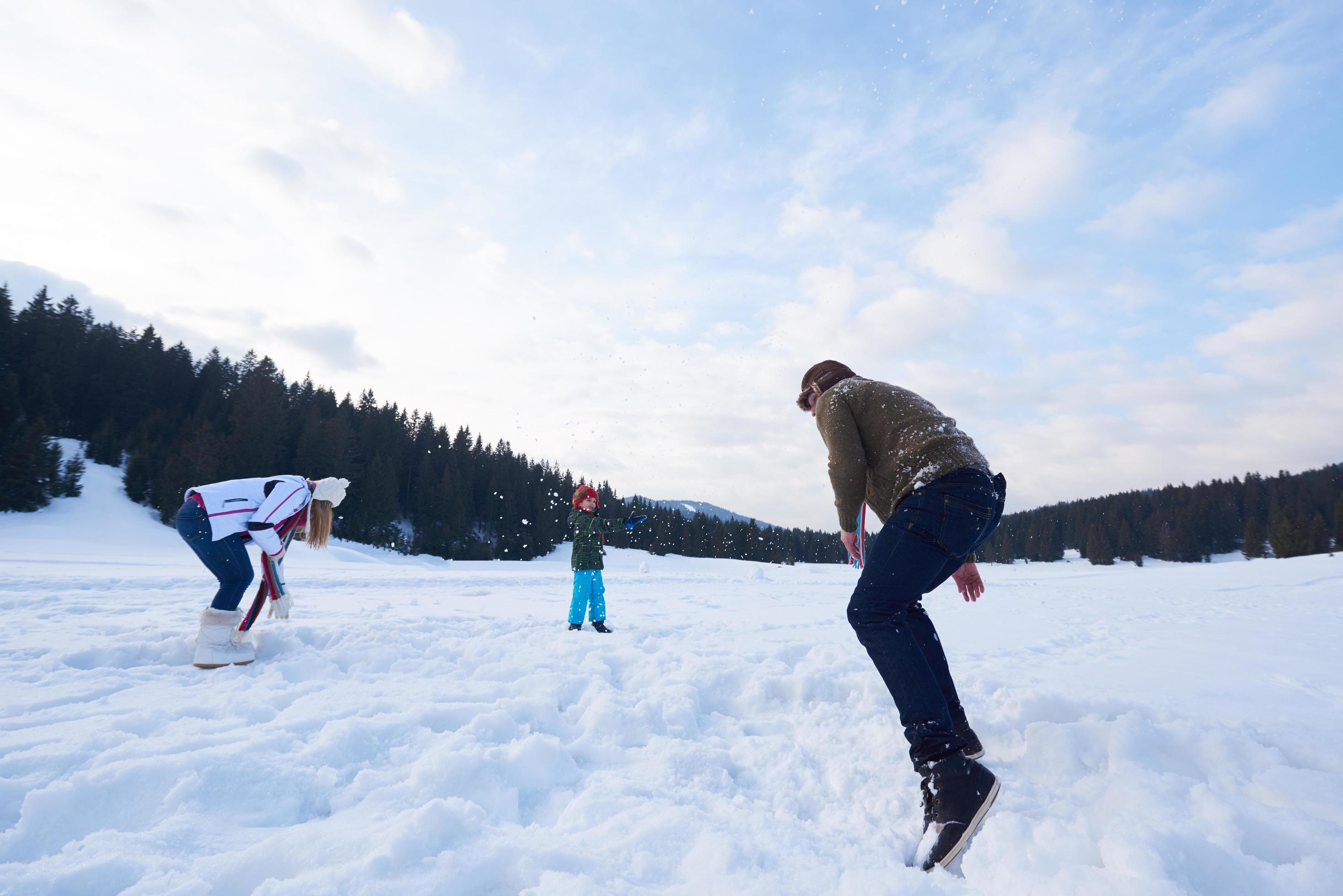 happy family playing together in snow at winter Stock Free