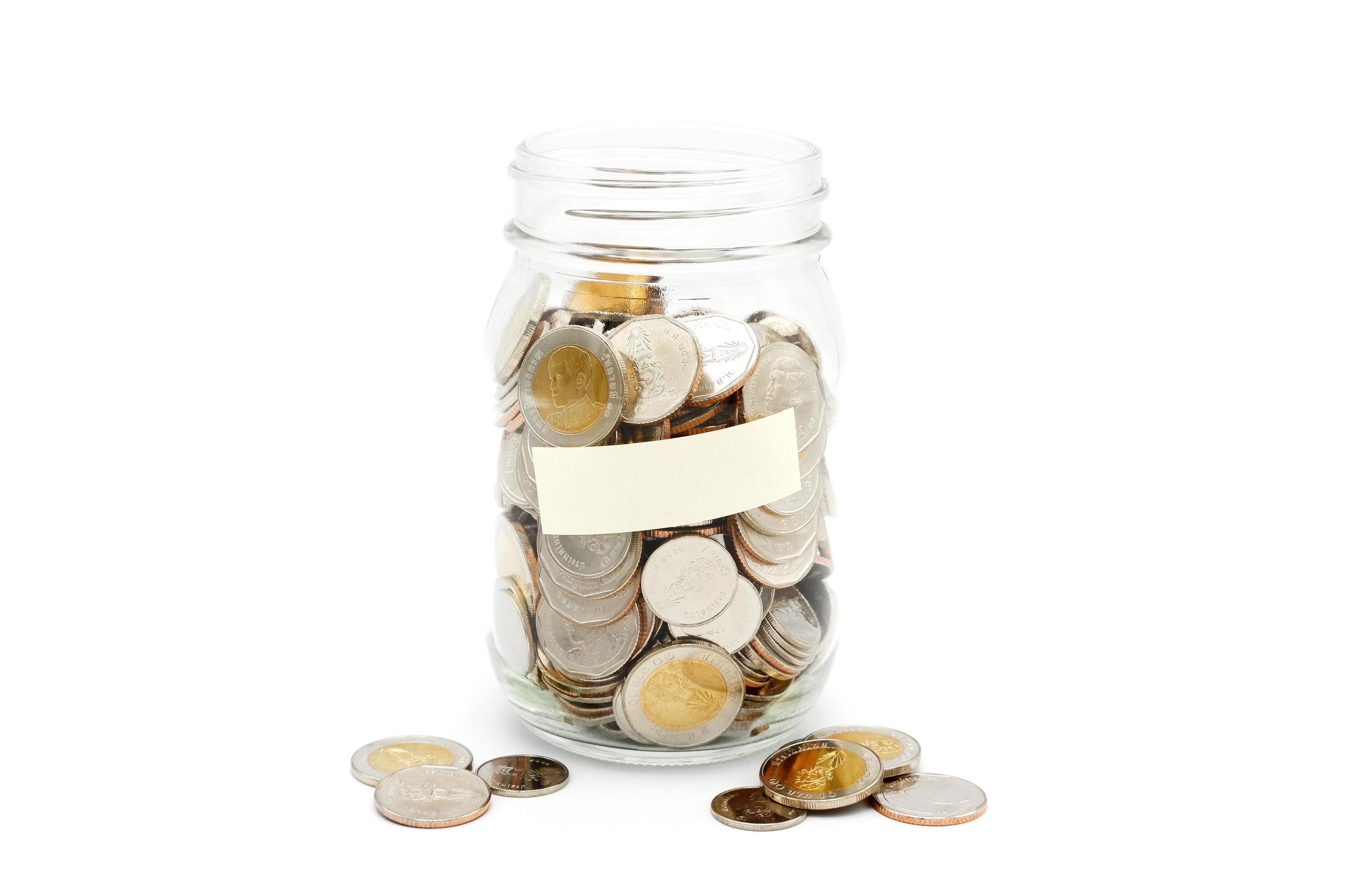 Thai Baht coins in a glass jar. Business and finance concept. Stock Free