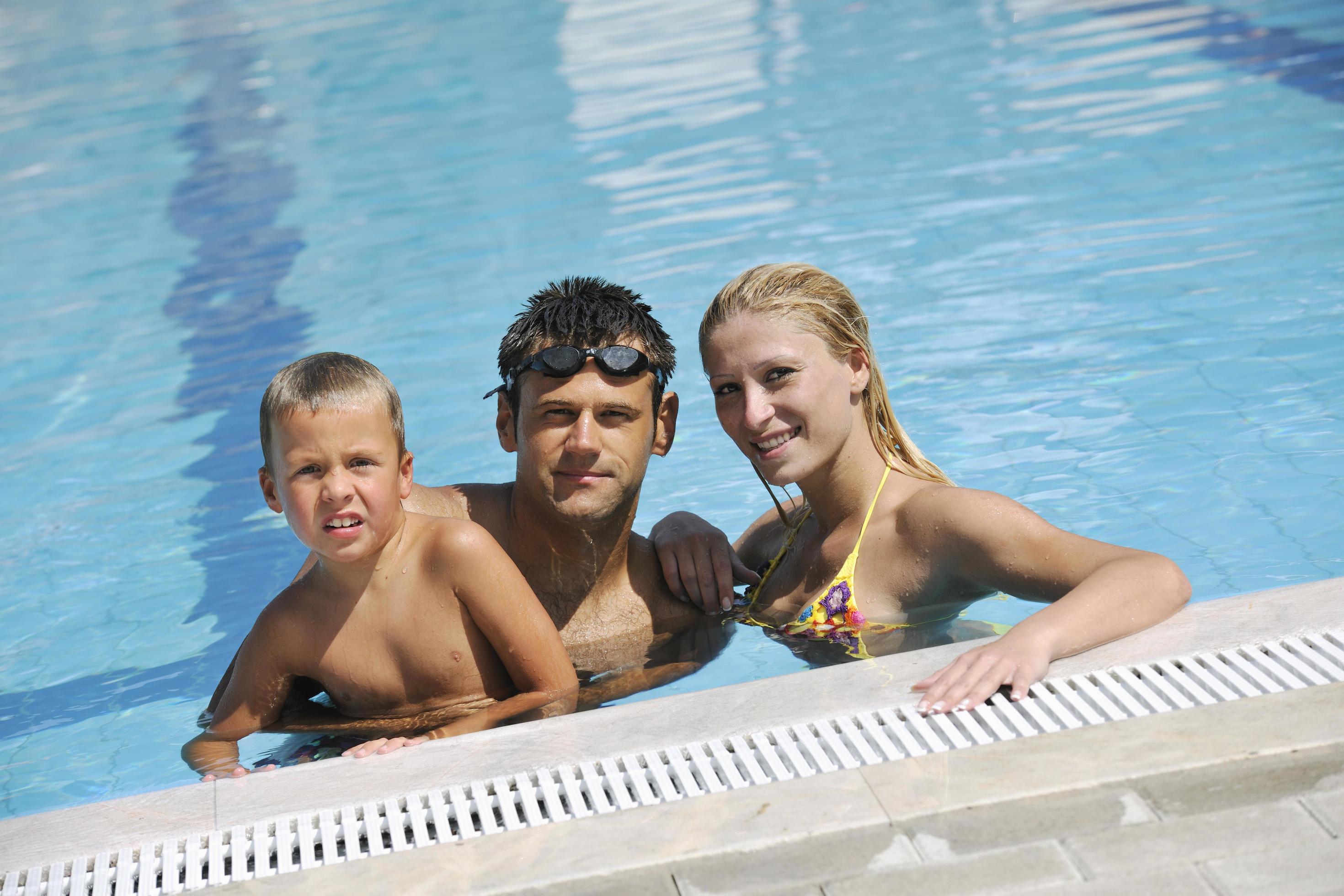 happy young family have fun on swimming pool Stock Free