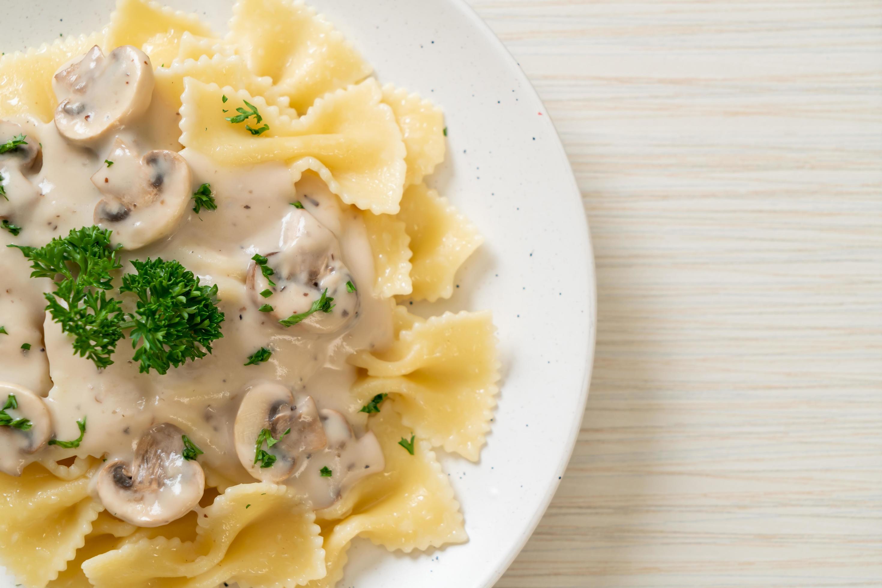 Farfalle pasta with mushroom white cream sauce – Italian food style Stock Free