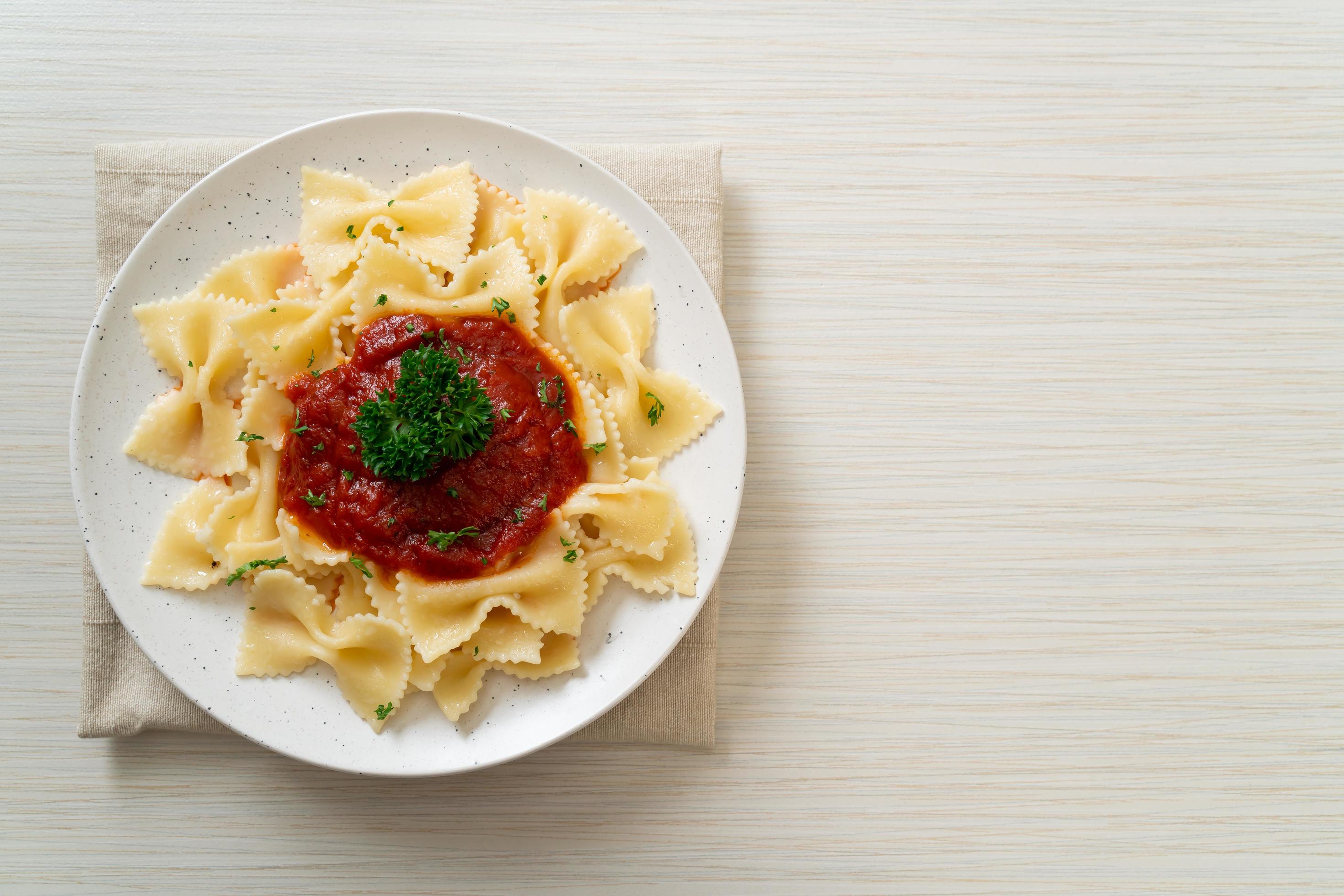 Farfalle pasta in tomato sauce with parsley – Italian food style Stock Free