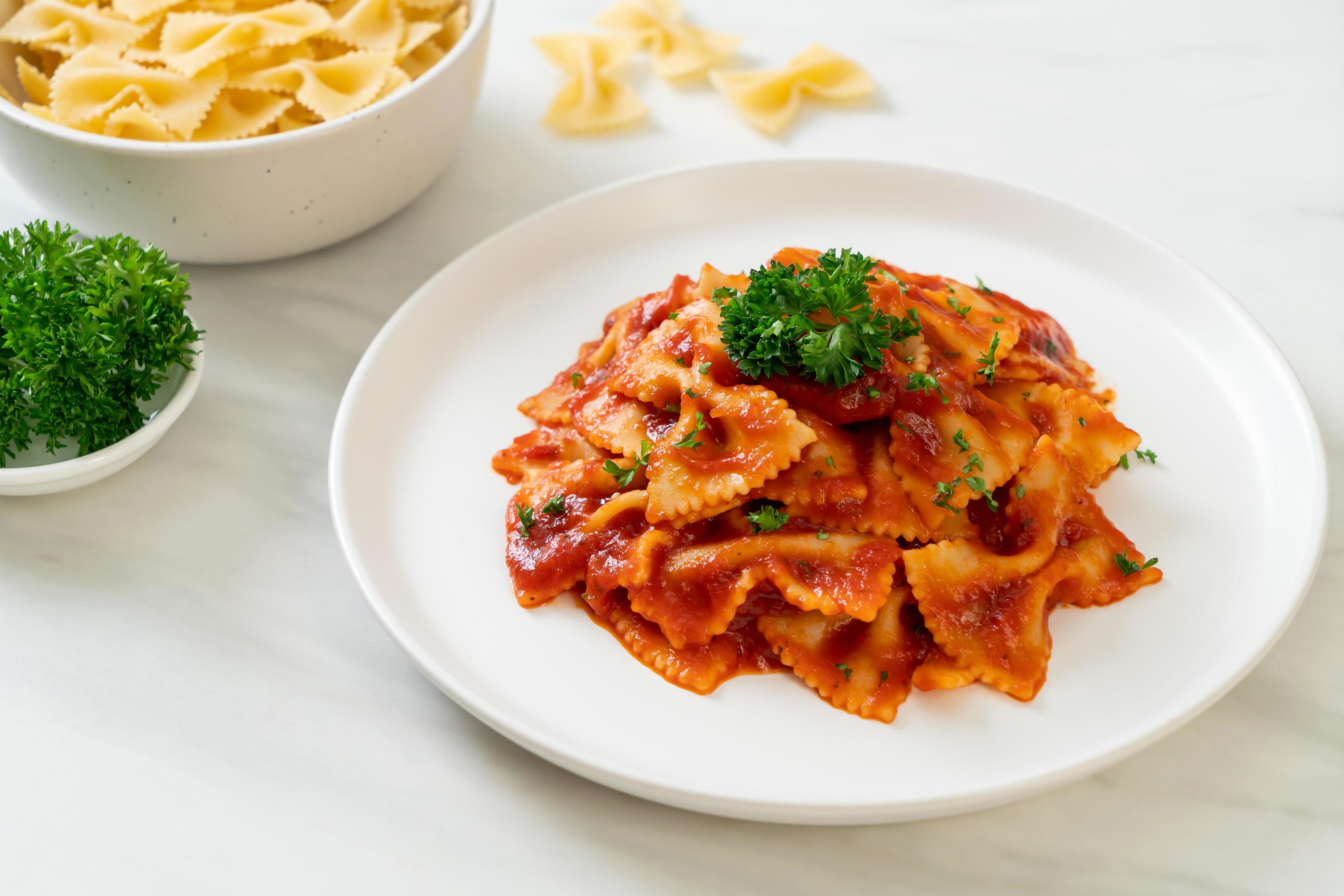 Farfalle pasta in tomato sauce with parsley – Italian food style Stock Free