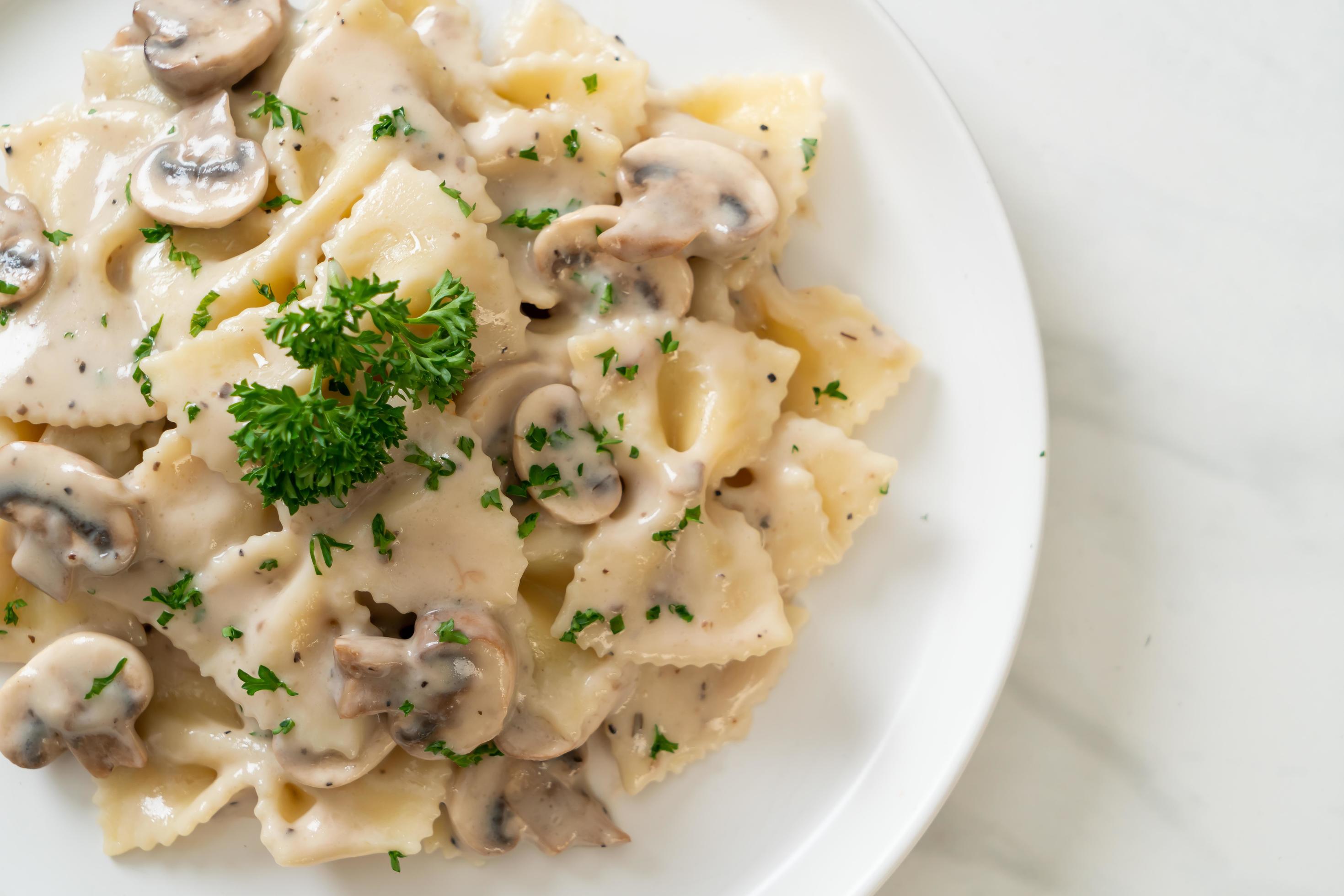 Farfalle pasta with mushroom white cream sauce – Italian food style Stock Free