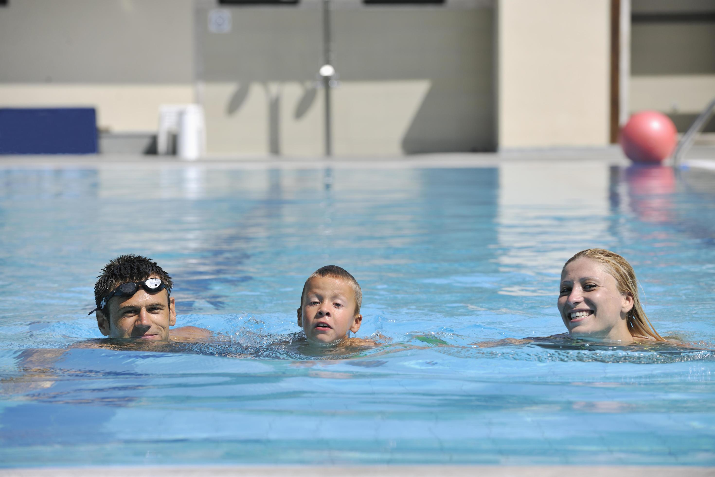 happy young family have fun on swimming pool Stock Free