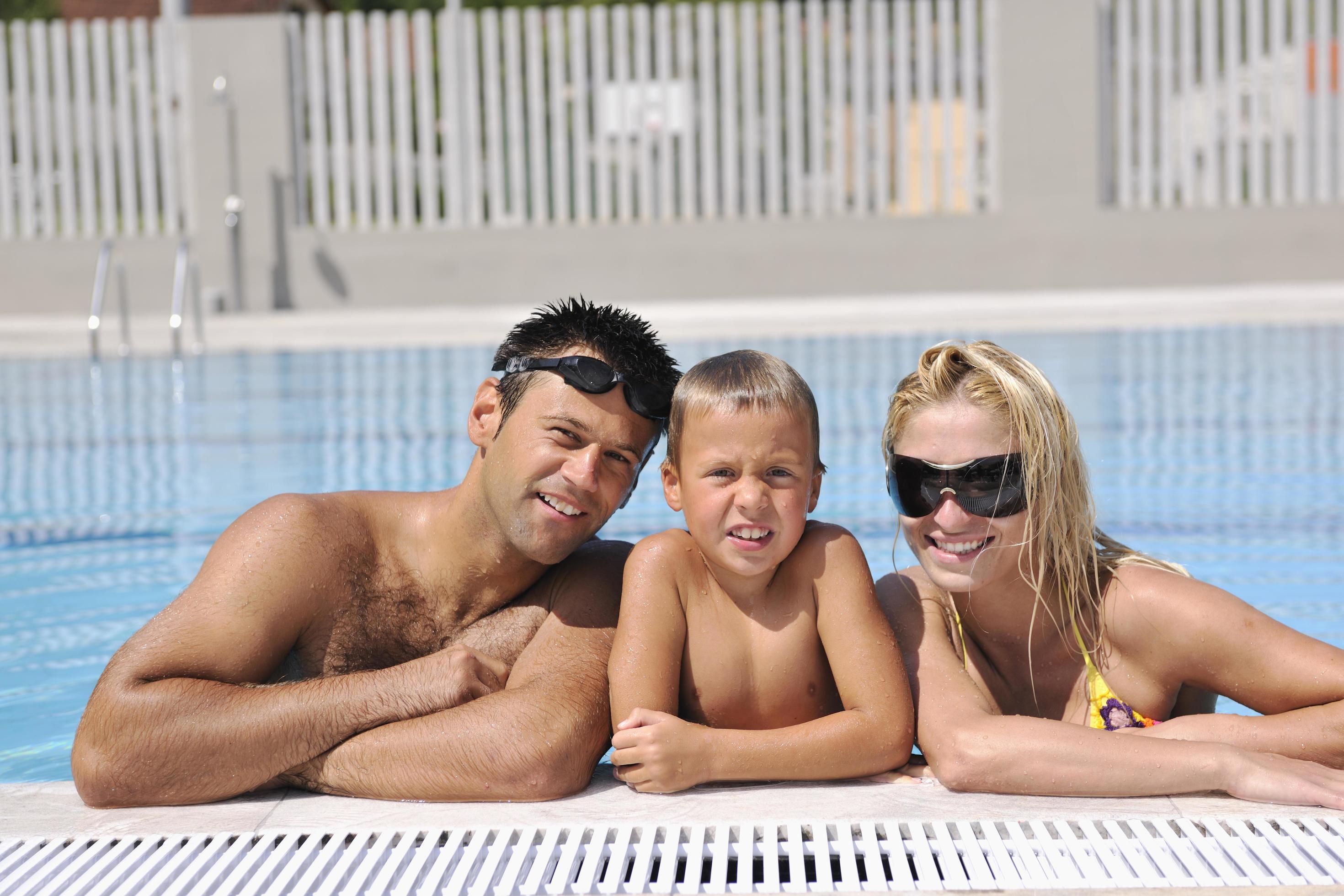 happy young family have fun on swimming pool Stock Free