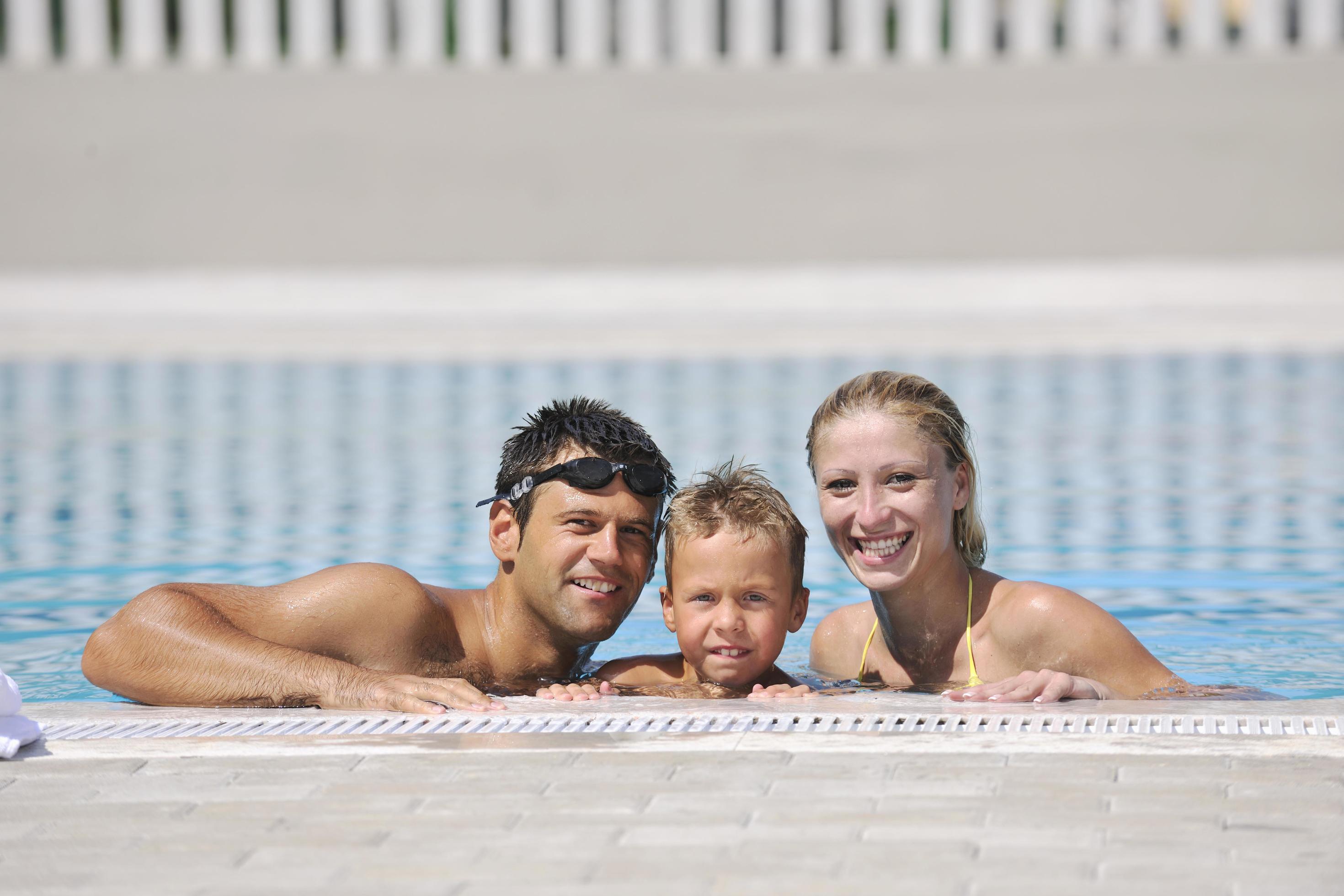 happy young family have fun on swimming pool Stock Free