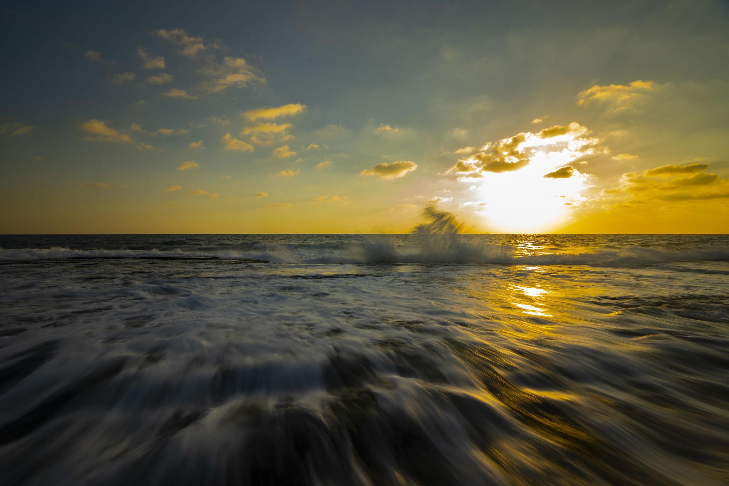 Long exposure photography of waves and pebbles on Beach in the sunset Stock Free