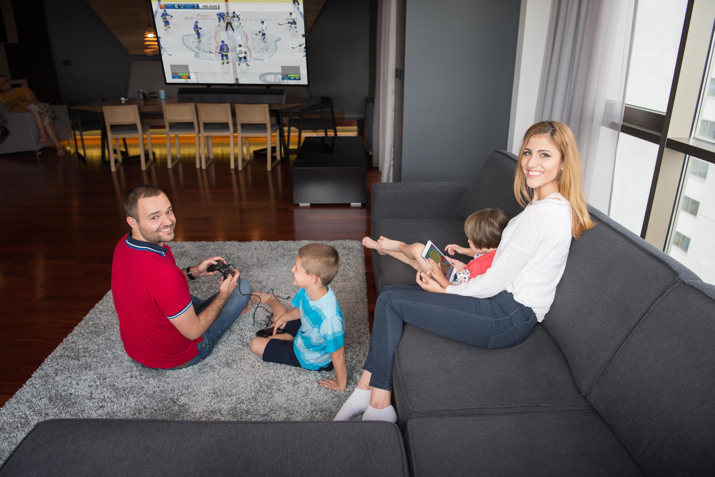 
									Happy family playing a hockey video game Stock Free