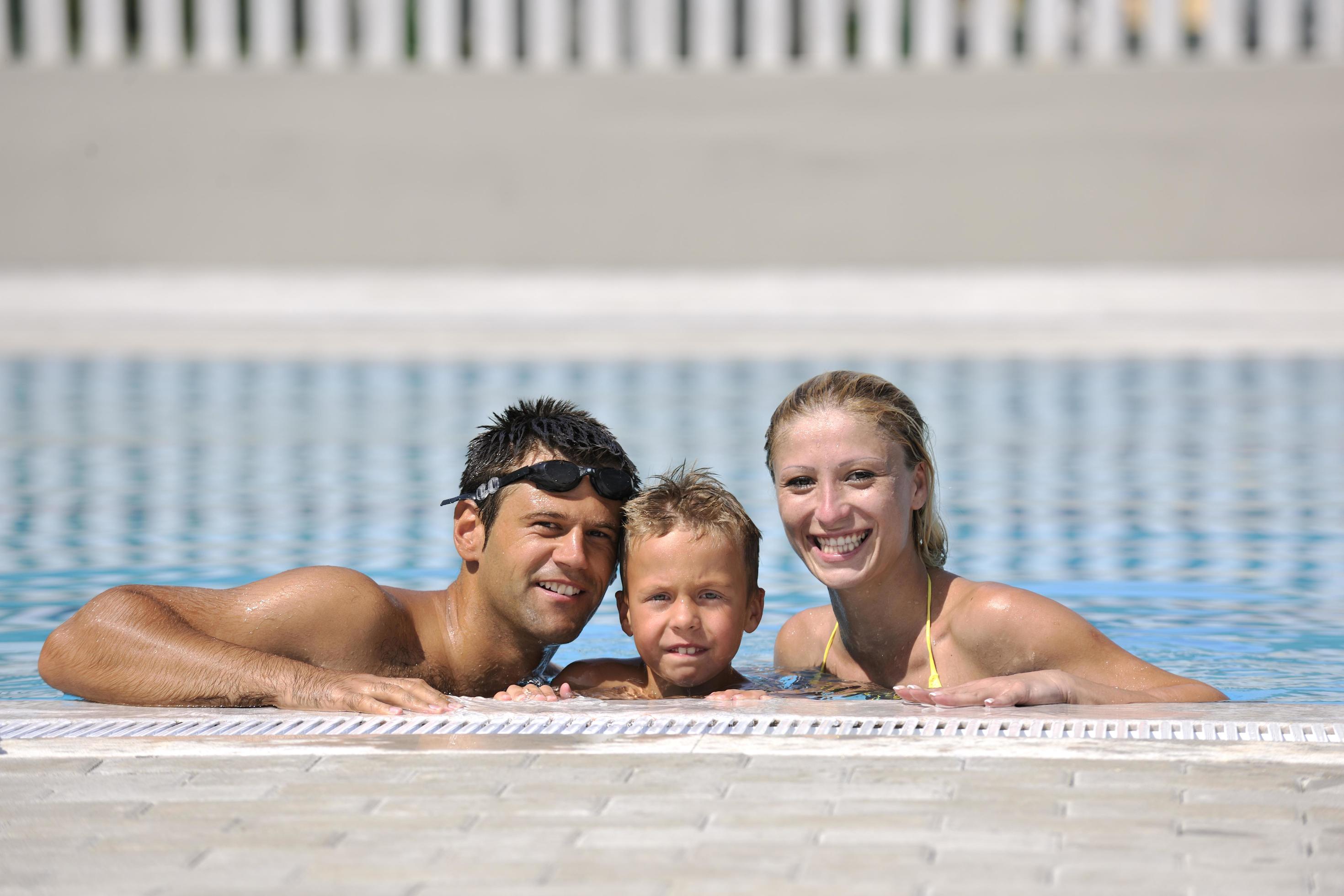 happy young family have fun on swimming pool Stock Free