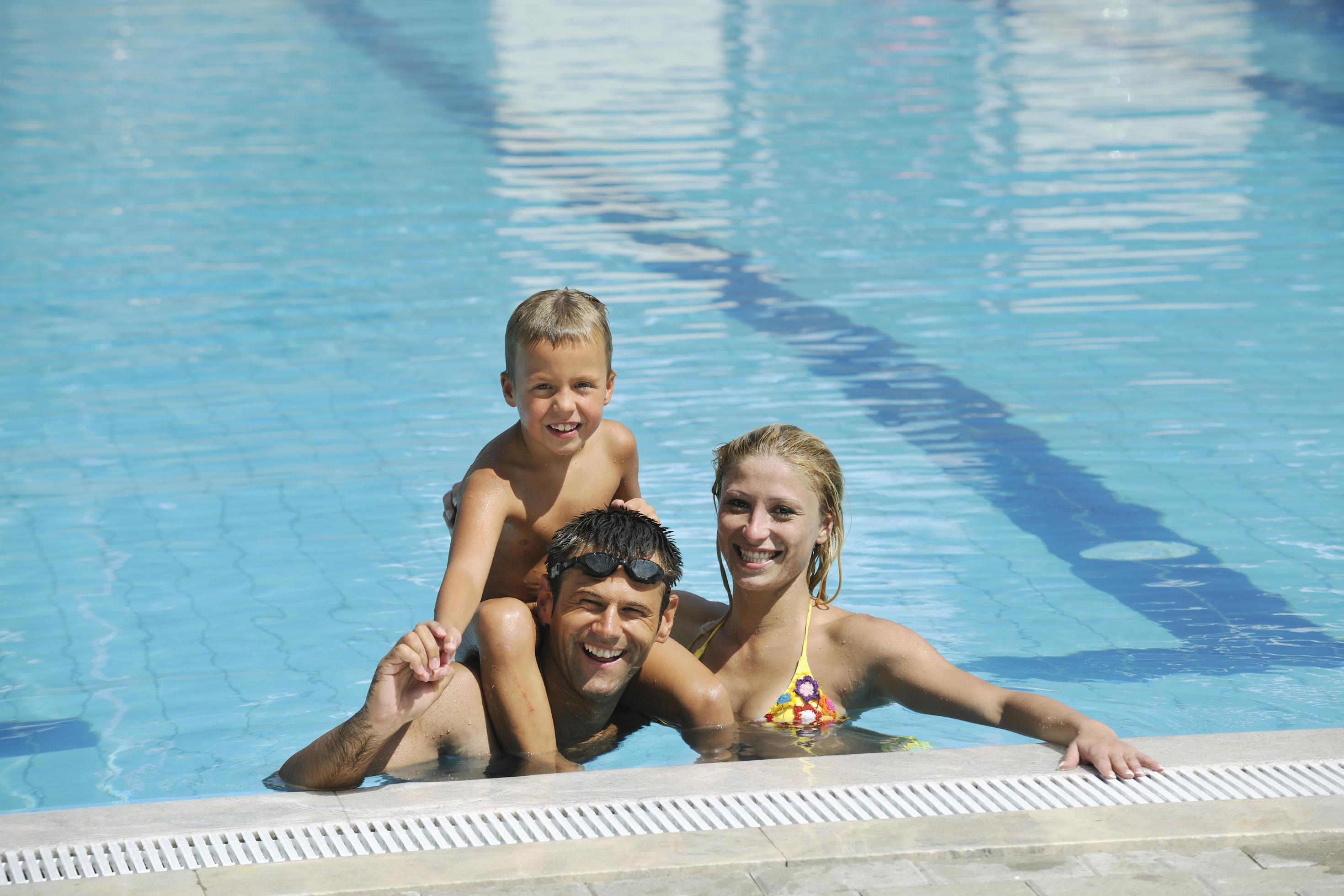 happy young family have fun on swimming pool Stock Free