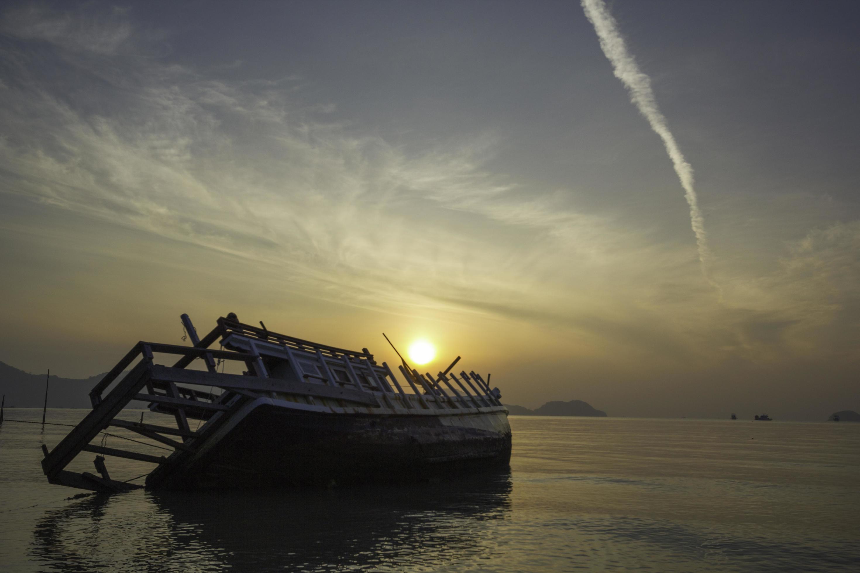 
									Sinking boat in the sunrise sea Stock Free