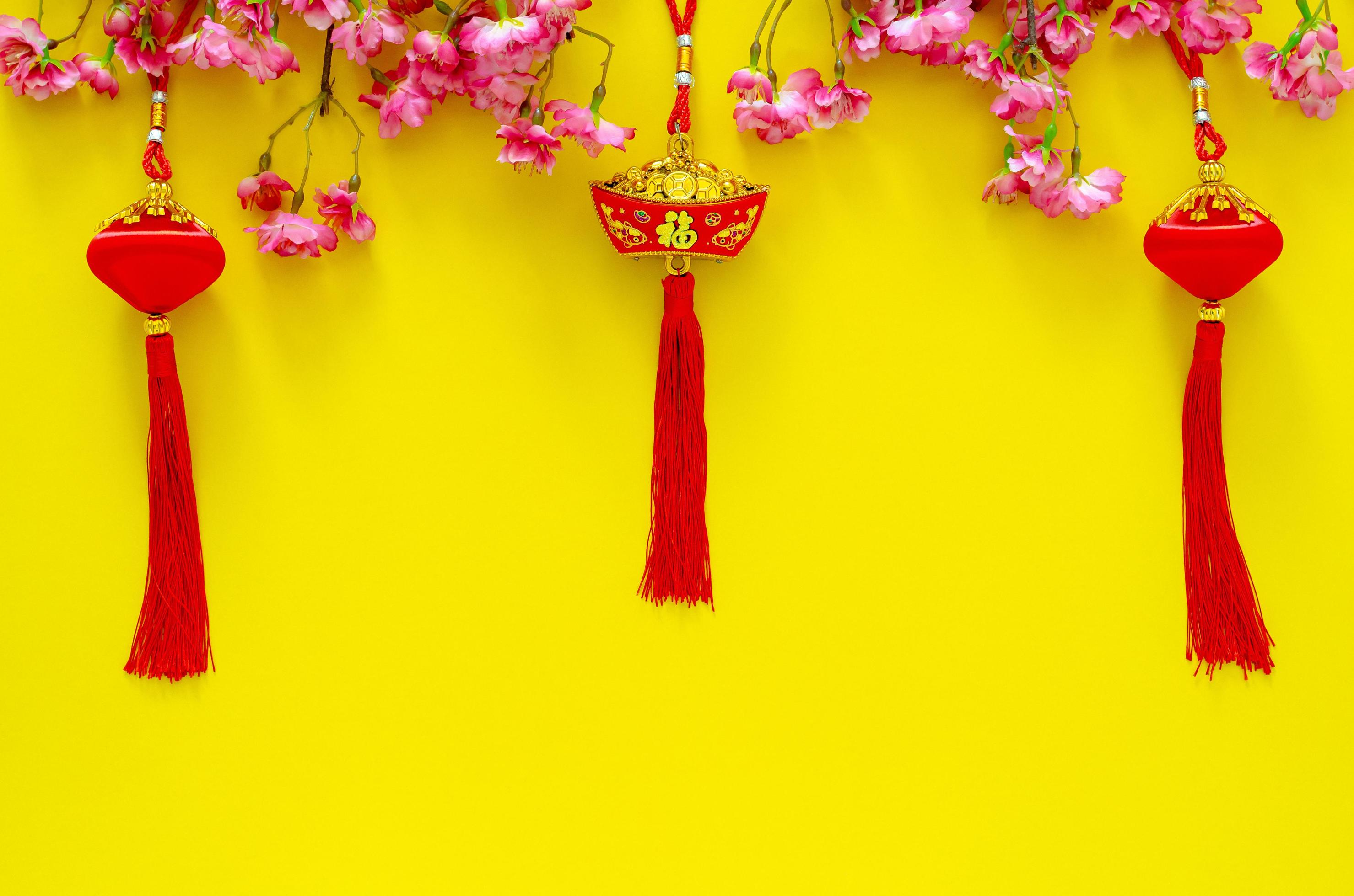 Hanging pendants for Chinese new year ornament meaning of word is wealth with Chinese blossom flowers on yellow background. Stock Free