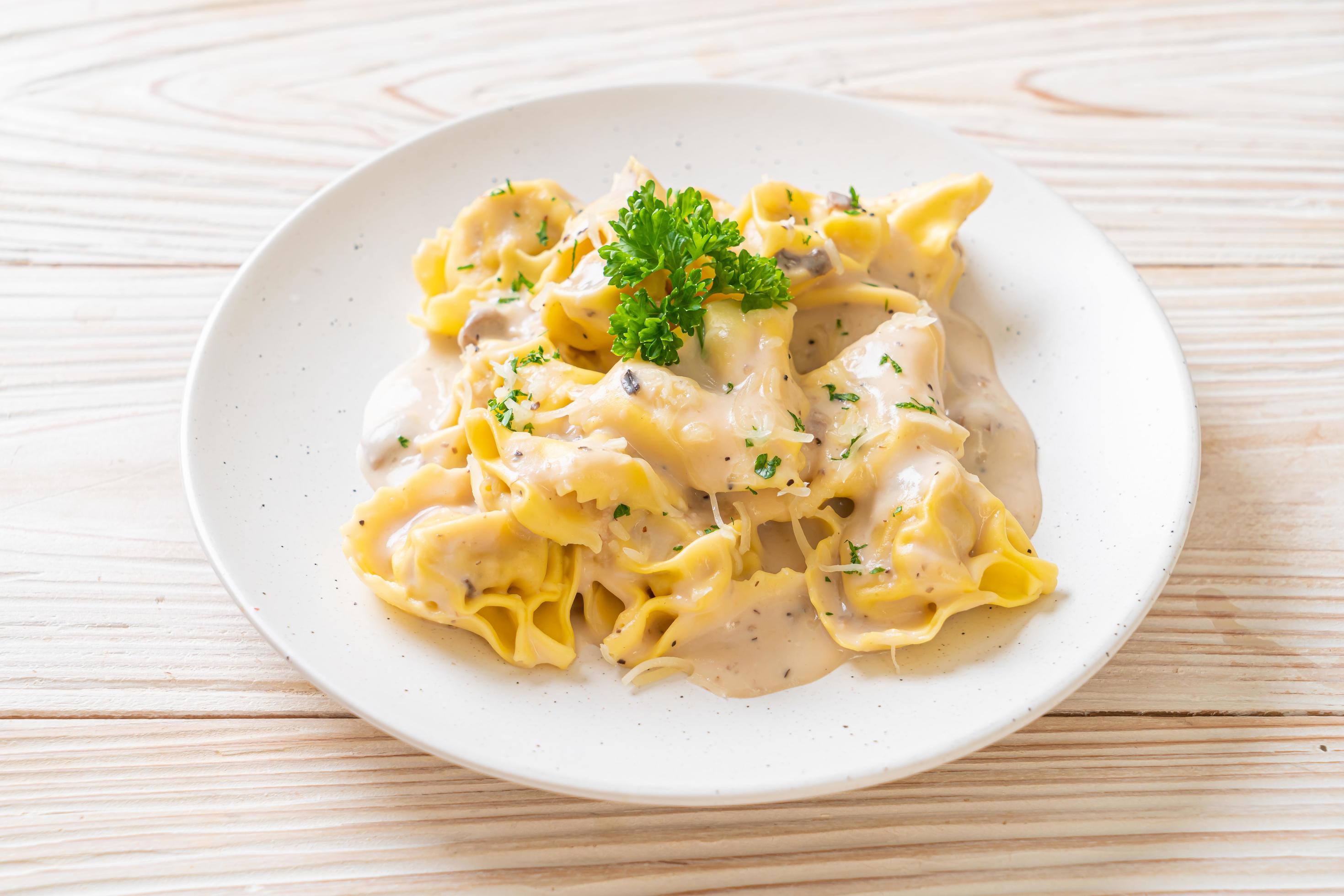 Tortellini pasta with mushroom cream sauce and cheese – Italian food style Stock Free