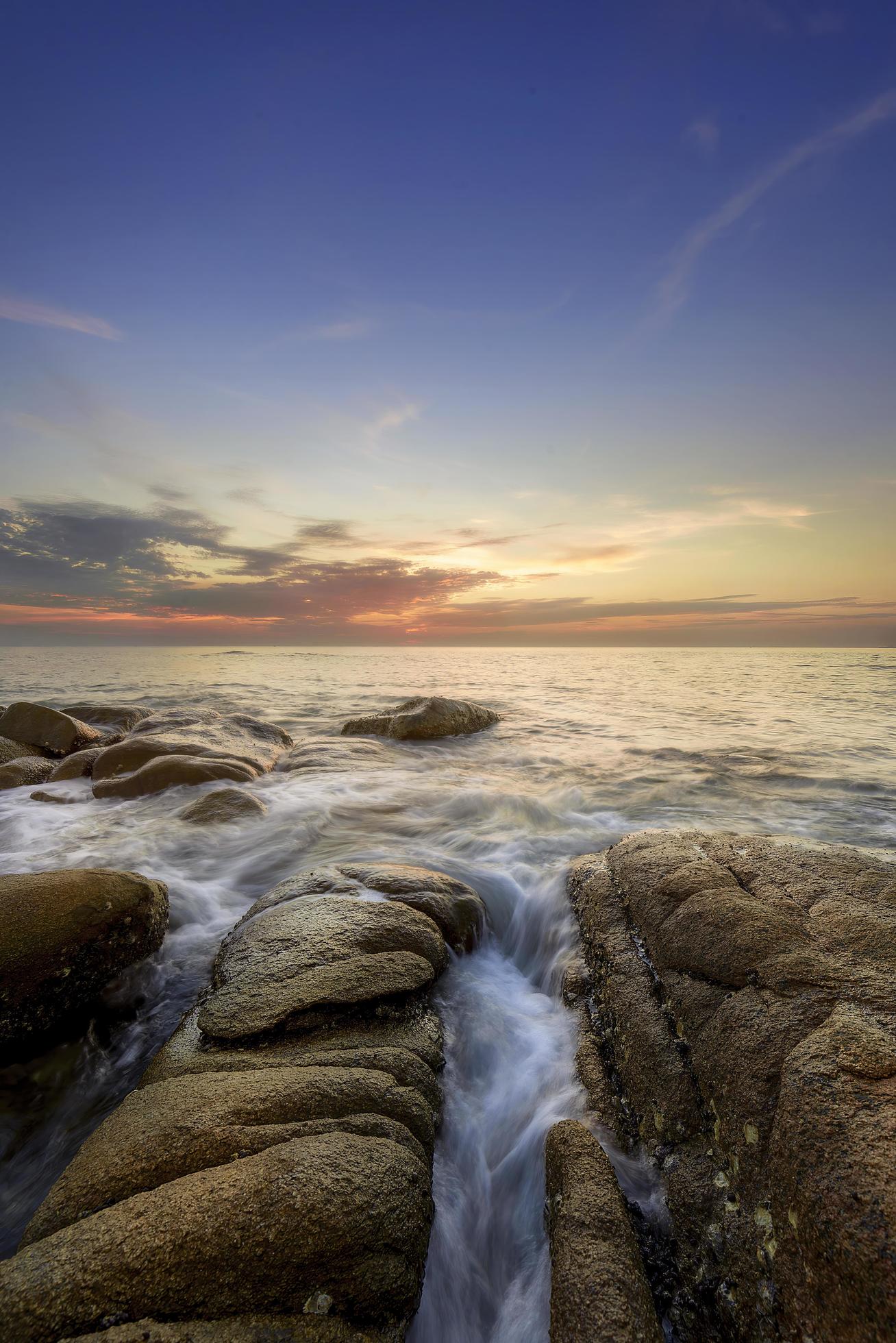 stones in the sea at sunset Stock Free