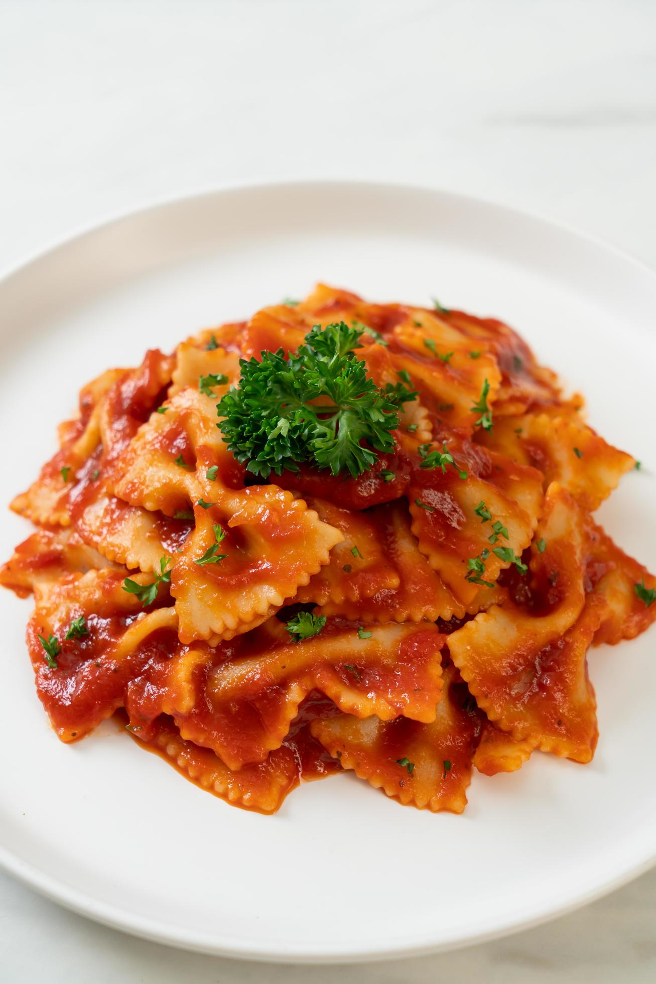 Farfalle pasta in tomato sauce with parsley – Italian food style Stock Free