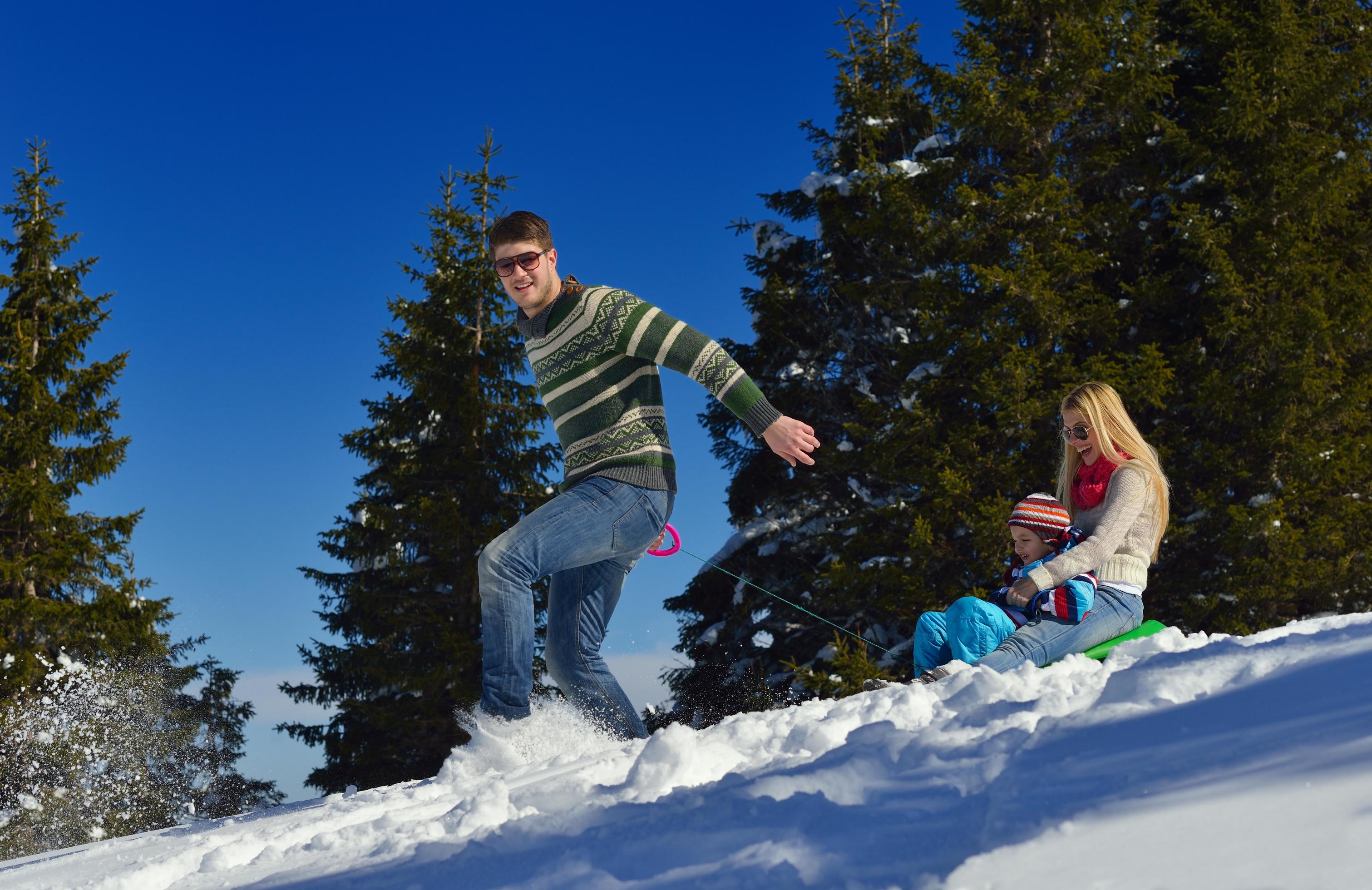 family having fun on fresh snow at winter vacation Stock Free