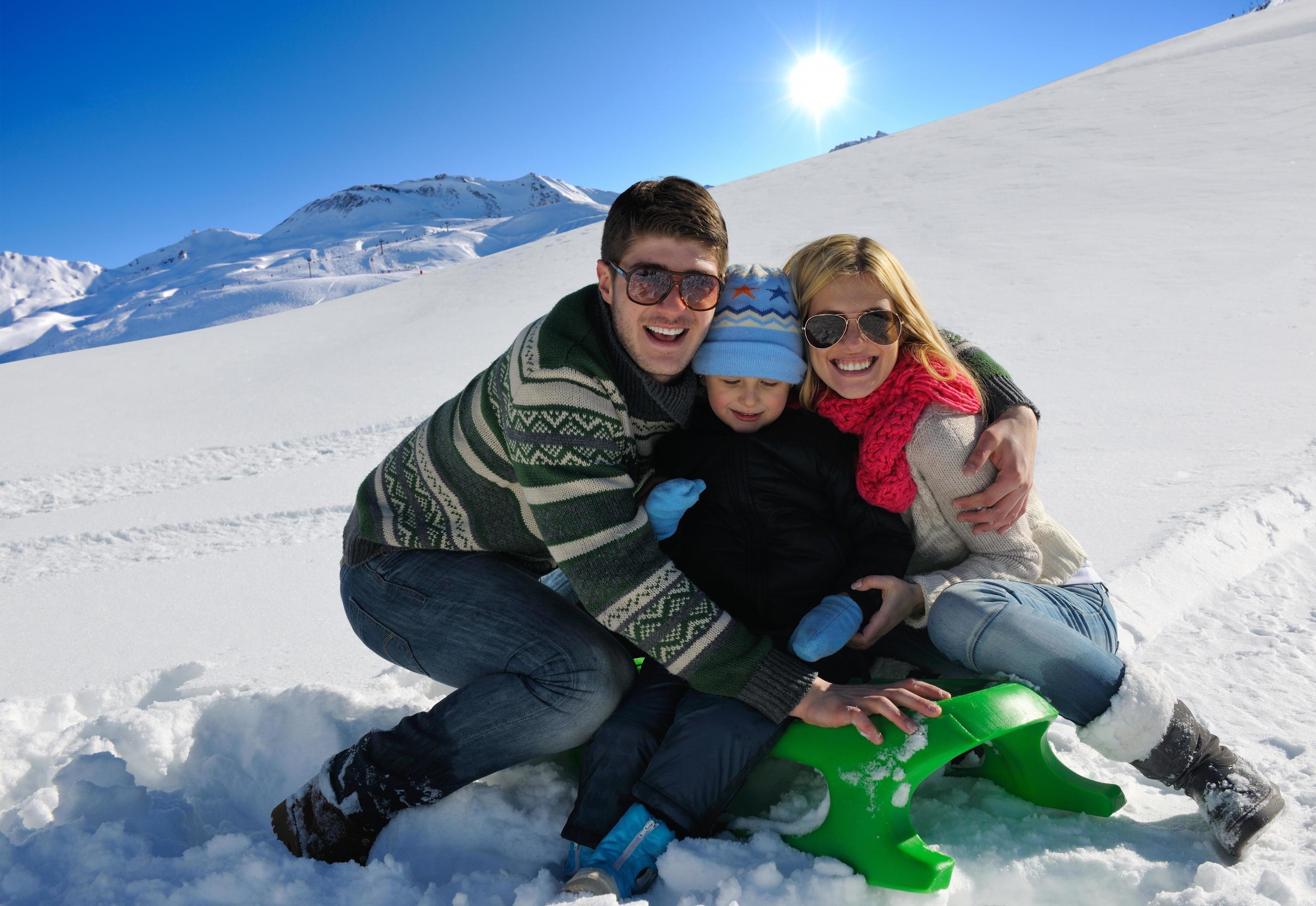 family having fun on fresh snow at winter vacation Stock Free