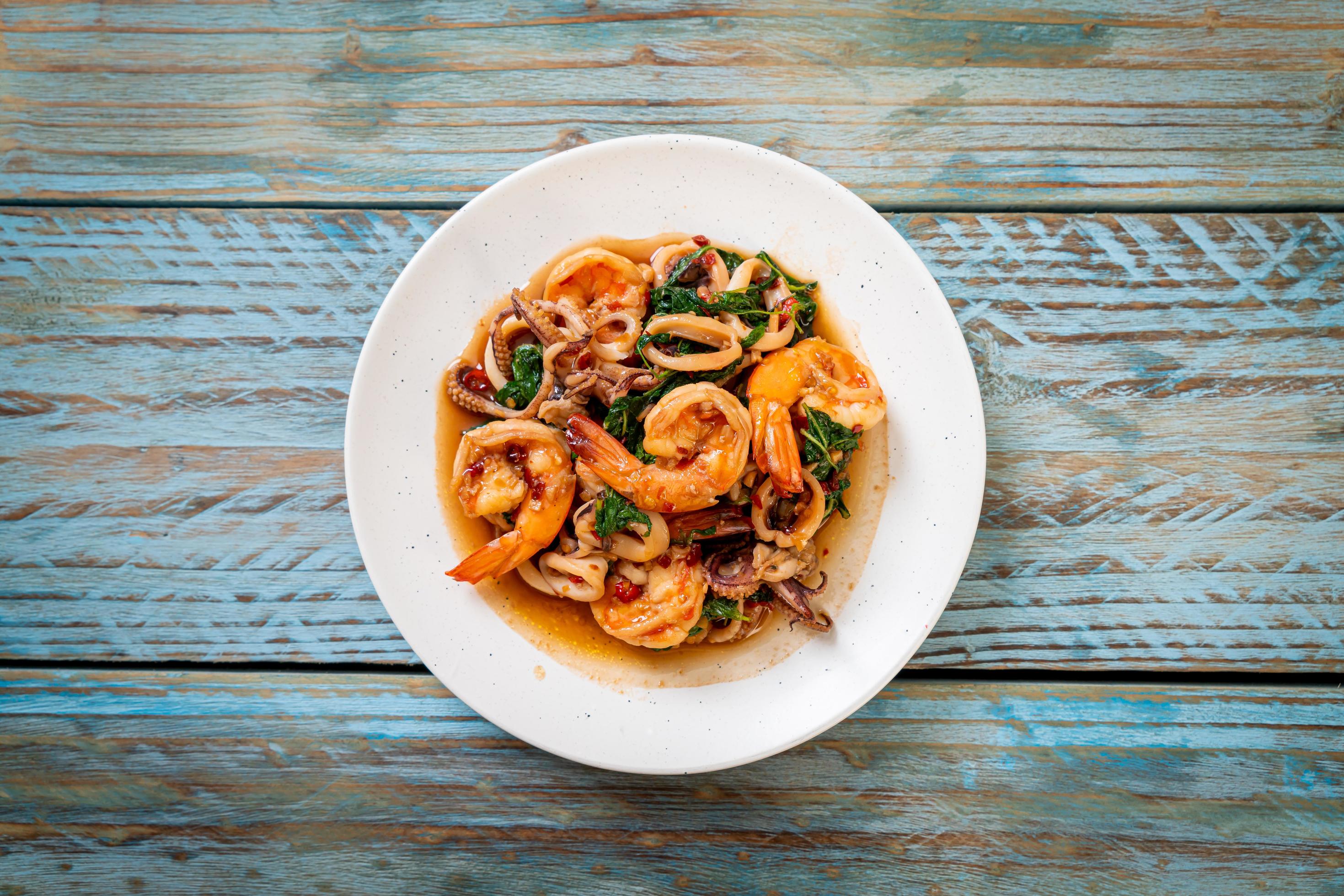 Stir-fried seafood of shrimp and squid with Thai basil – Asian food style Stock Free