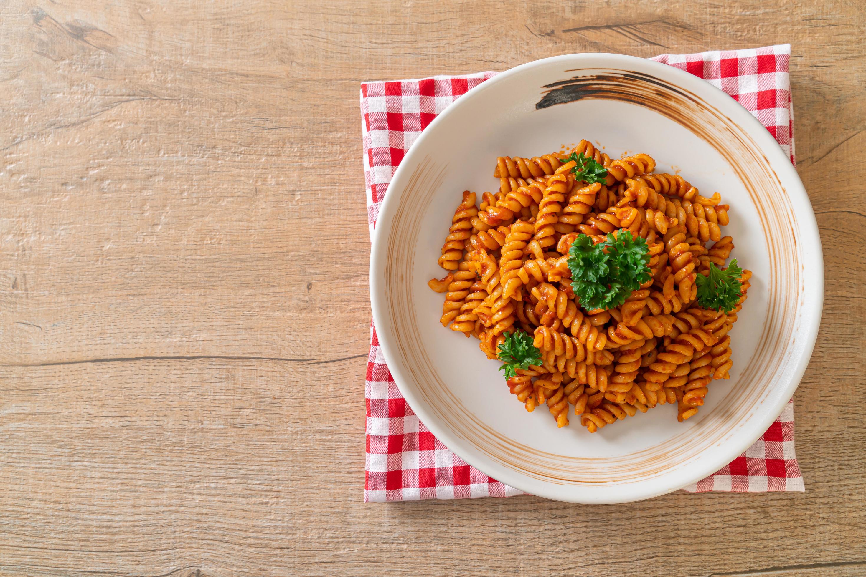 Spiral or spirali pasta with tomato sauce and sausage – Italian food style Stock Free