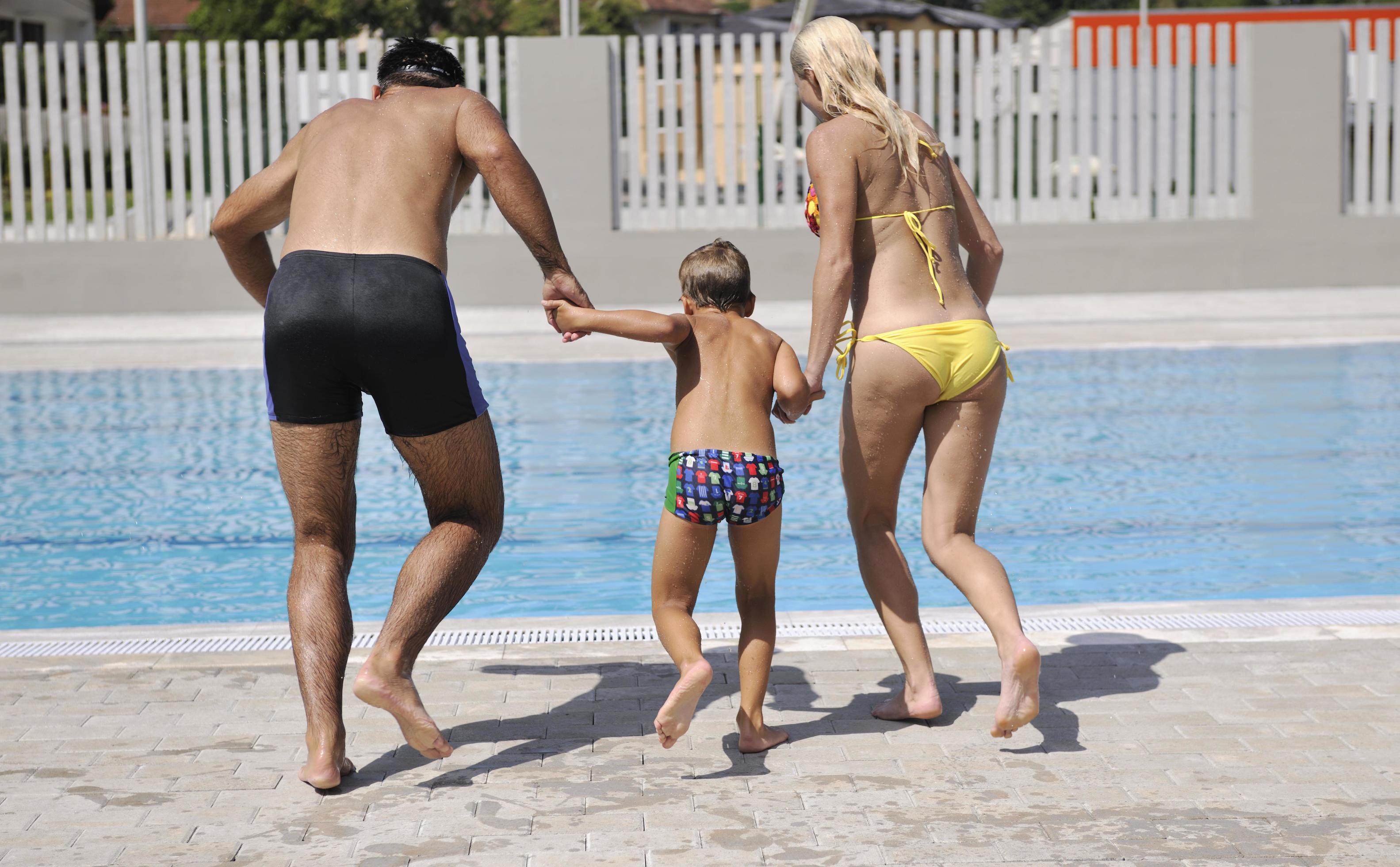 happy young family have fun on swimming pool Stock Free