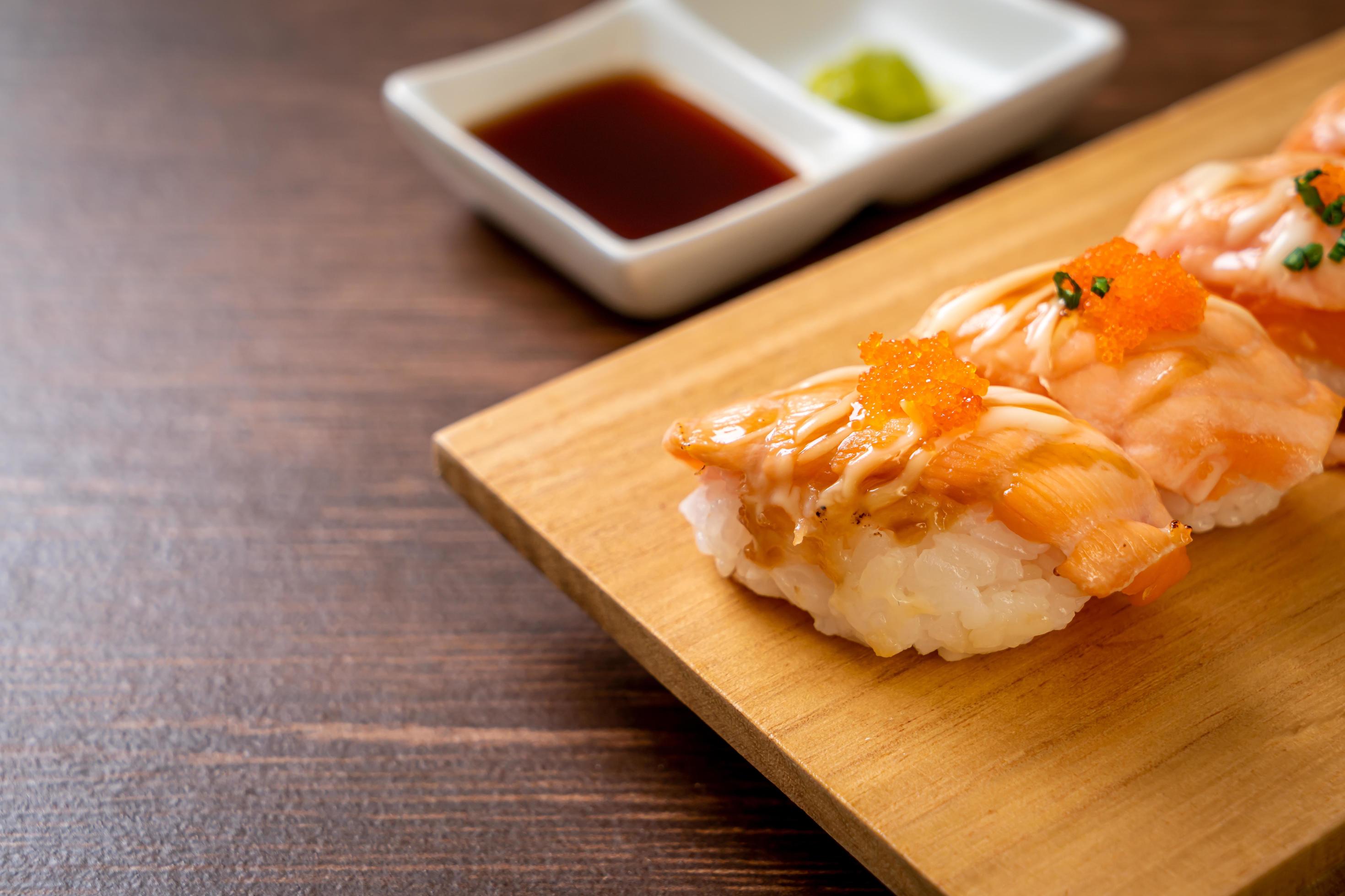 Grilled salmon sushi on a wood plate – Japanese food style Stock Free