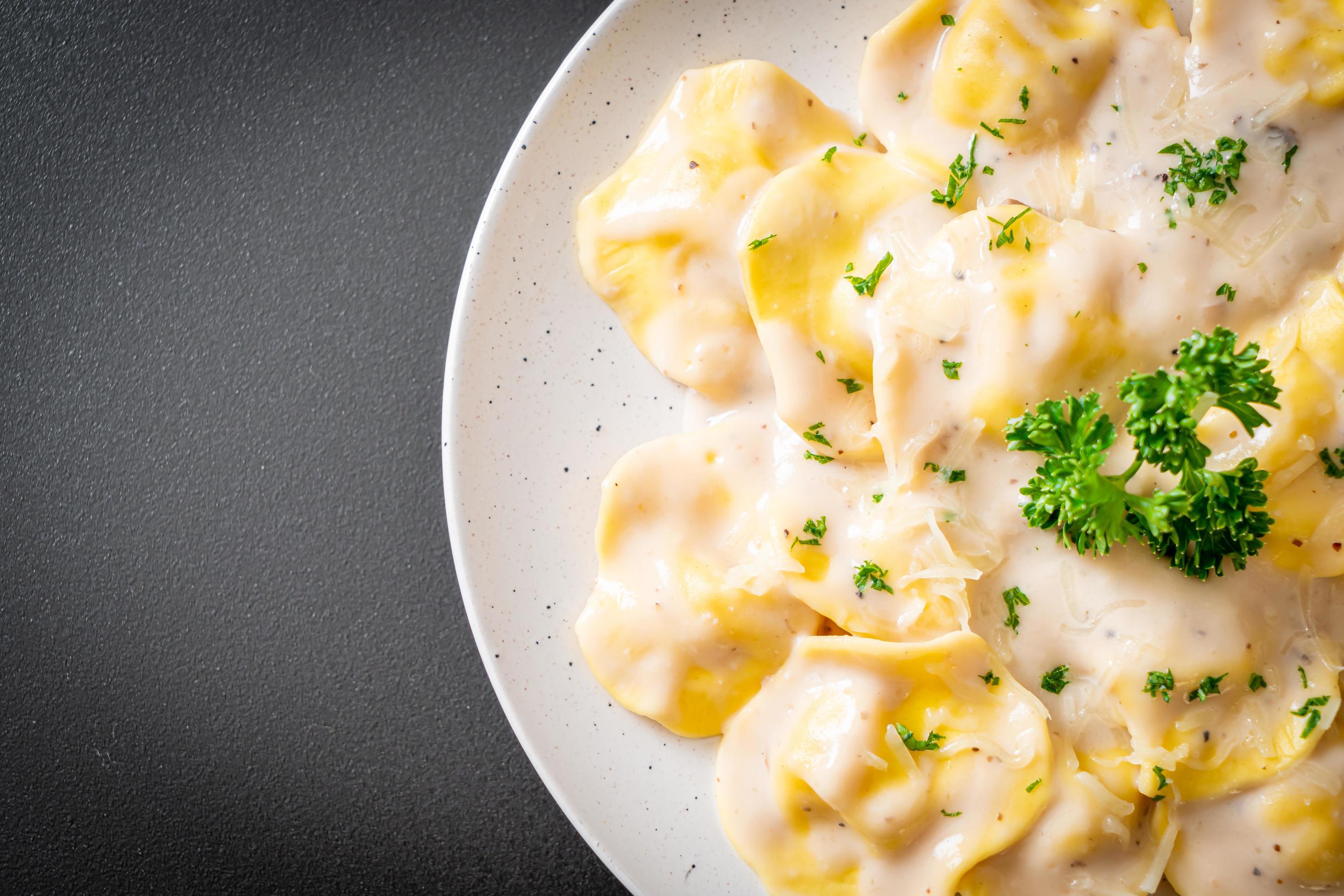 Ravioli pasta with mushroom cream sauce and cheese – Italian food style Stock Free