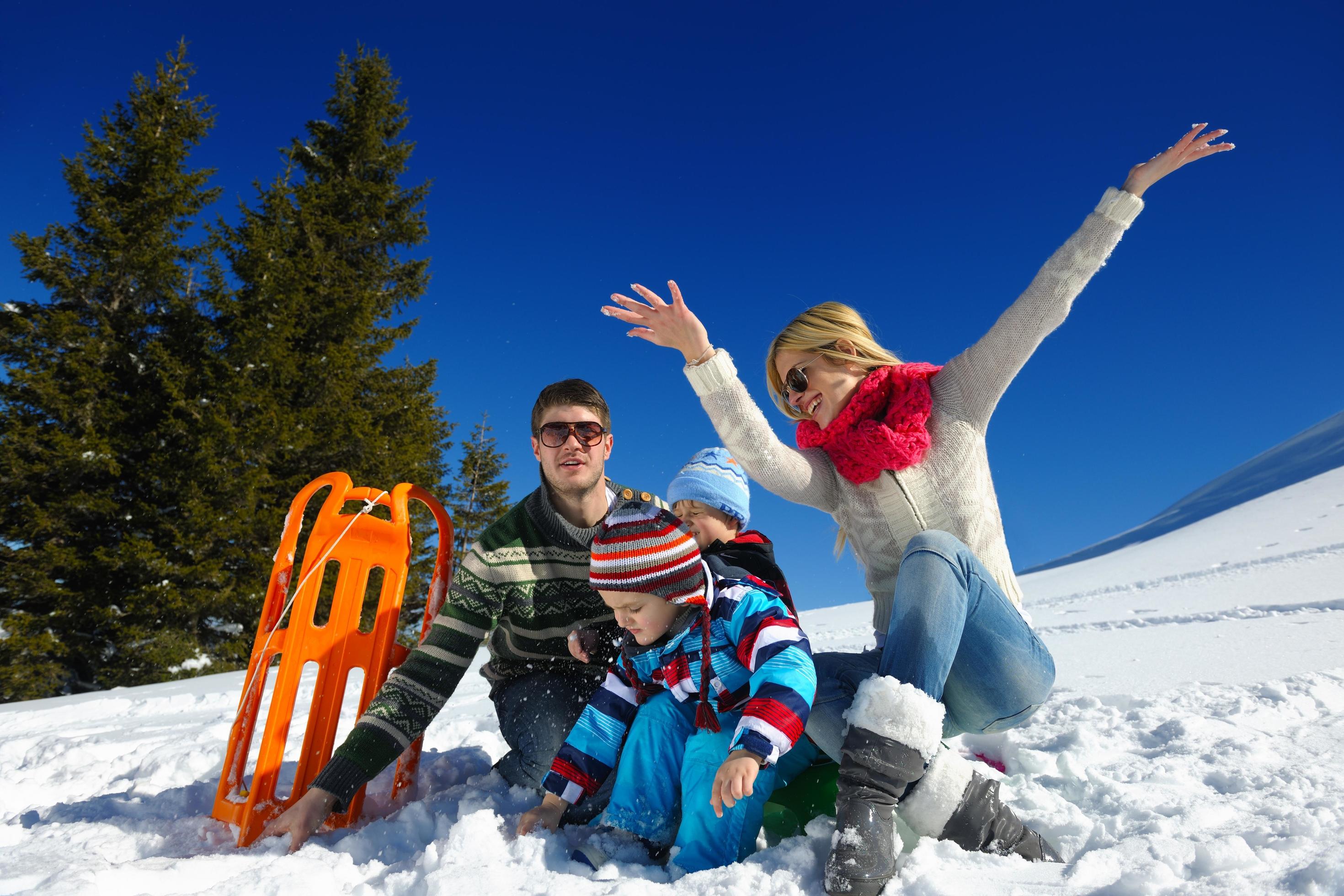 family having fun on fresh snow at winter vacation Stock Free