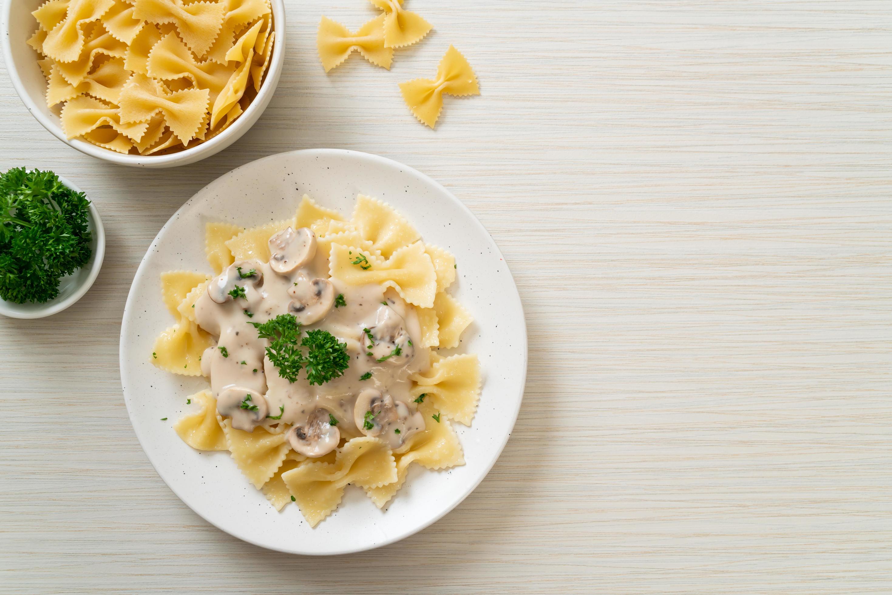 Farfalle pasta with mushroom white cream sauce – Italian food style Stock Free