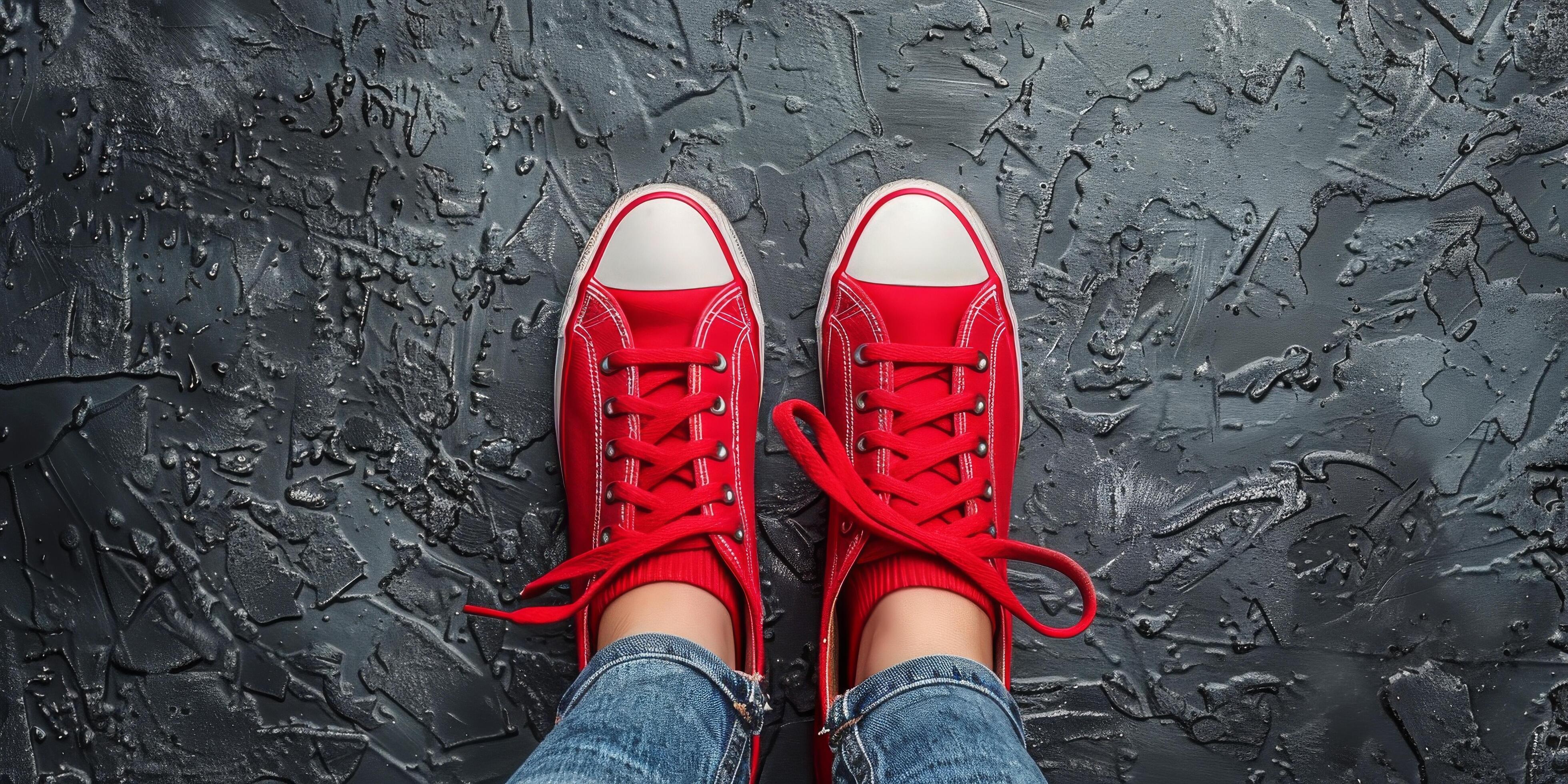 Persons Feet in Red Sneakers on Black Surface Stock Free