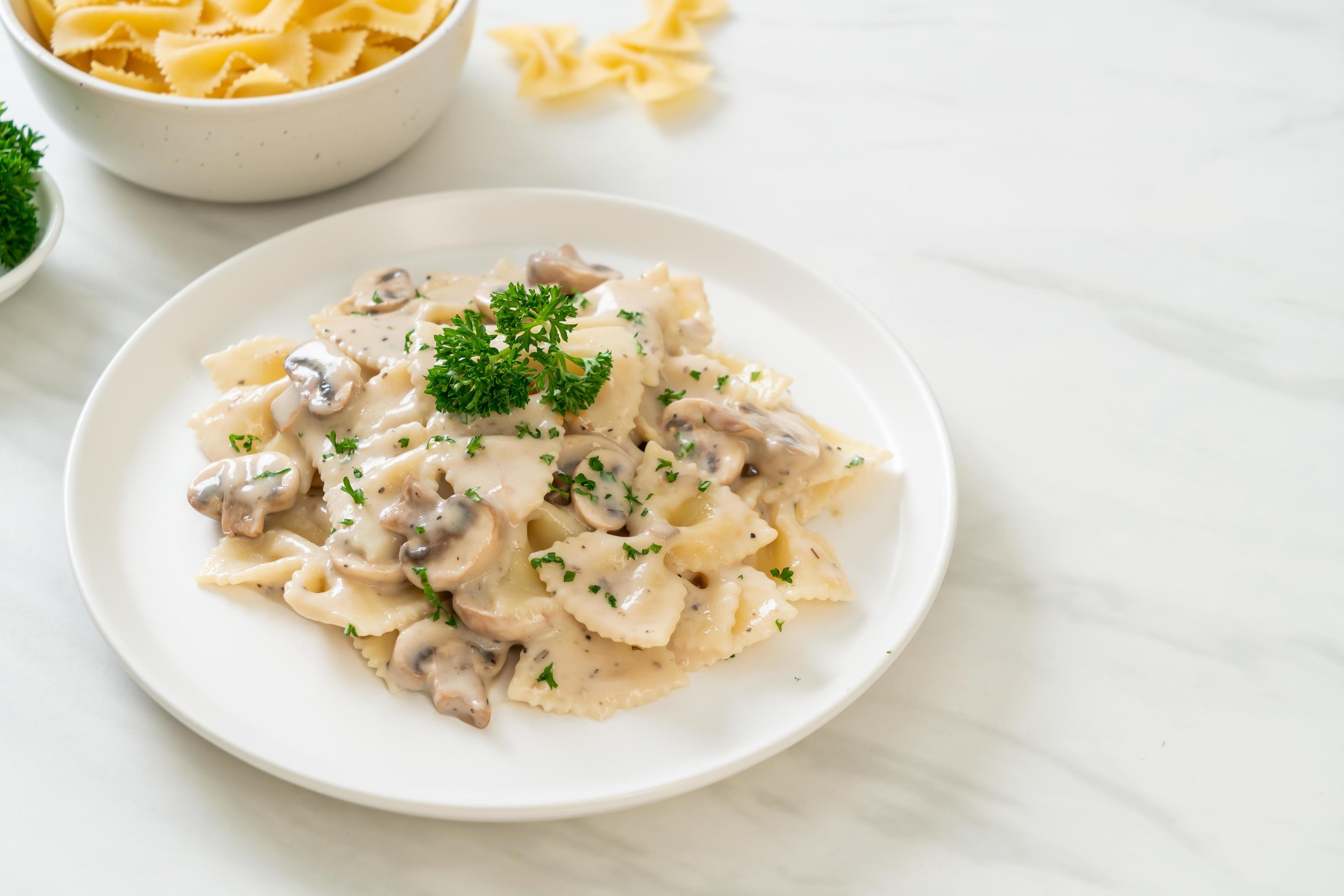 Farfalle pasta with mushroom white cream sauce – Italian food style Stock Free